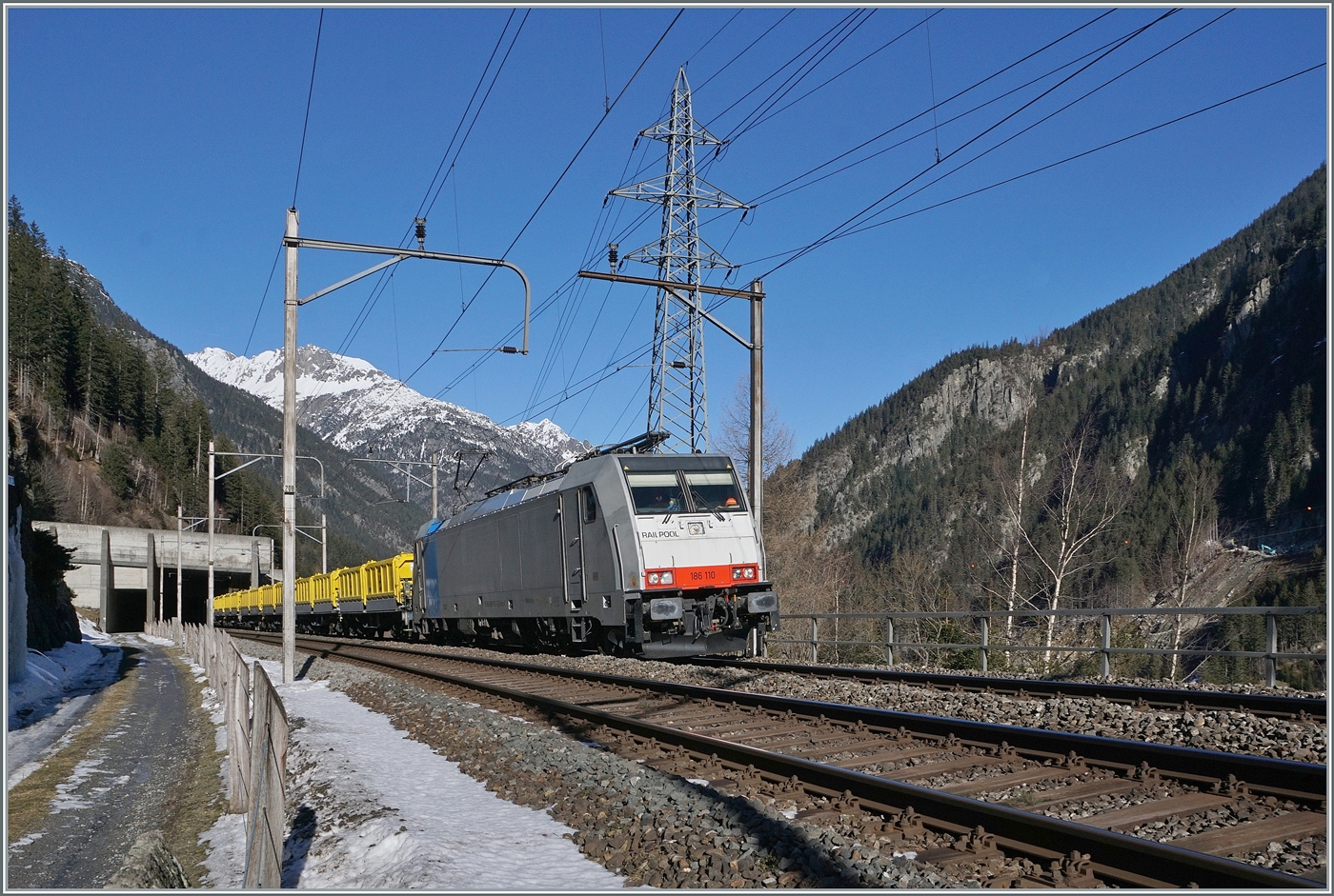 Da der 1981 erffnete Strassen Gotthardtunnel saniert werden muss, leistet man sich den Luxus, fr die Zeit der Sanierung eine zweite Rhre zu bauen. Nach der Sanierung werden beide Rhren durch den richtungsgetrennten Verkehr mehr Sicherheit bieten, drfen aber nur eine Spur pro Rhre aufweisen, es wird interessant sein, ob dies dann auch eingehalten werden wird...
Das Aushubmaterial wird per Bahn nach Flelen transportiert. Das Bild zeigt die Railpool 186 110 mit einem aus Sggrrs S204 Wagen gebildeten Ganzzug kurz vor Gschenen. 

21. Januar 2025