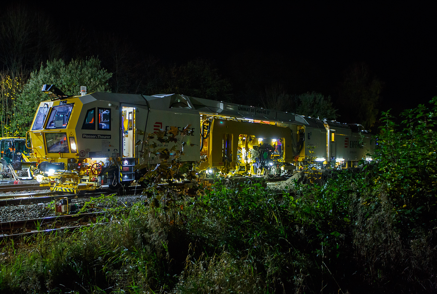 Damit hatte ich nicht gerechnet, aber als ich erkannte was es ist, so musste ich trotz der Dunkelheit nochmal zur Baustelle. Ich hatte eher an eine Maschine der DGU gedacht, da die KAF Falkenhahn Bau AG dort Miteigent�mer ist, aber nein es war eine hochmoderne Maschine der Eiffage Infra-Rail. 

Die Baustelle Bahnhof Herdorf am Abend des 26 Oktober 2025 (20:32 Uhr), nun wird gleich die neue Weiche 3, beim Bahnhof/Stellwerk Herdorf Fahrdienstleiter (Hf), gestopft. Hier kam die recht neue Plasser & Theurer UNIMAT 09-4x4/4S E� (A-PLA 99 81 9124 004-8), eine Universal-Weichenstopfmaschine mit Hybrid-Antriebstechnik, der Firma Eiffage Infra-Rail GmbH (Herne) zum Einsatz. Ob die Maschine nur von Eiffage Infra-Rail gemietet oder nun gekaut wurde ist mir nicht klar, aber eingestellt ist sie in �sterreich �ber Franz Plasser Vermietung von Bahnbaumaschinen GmbH. 