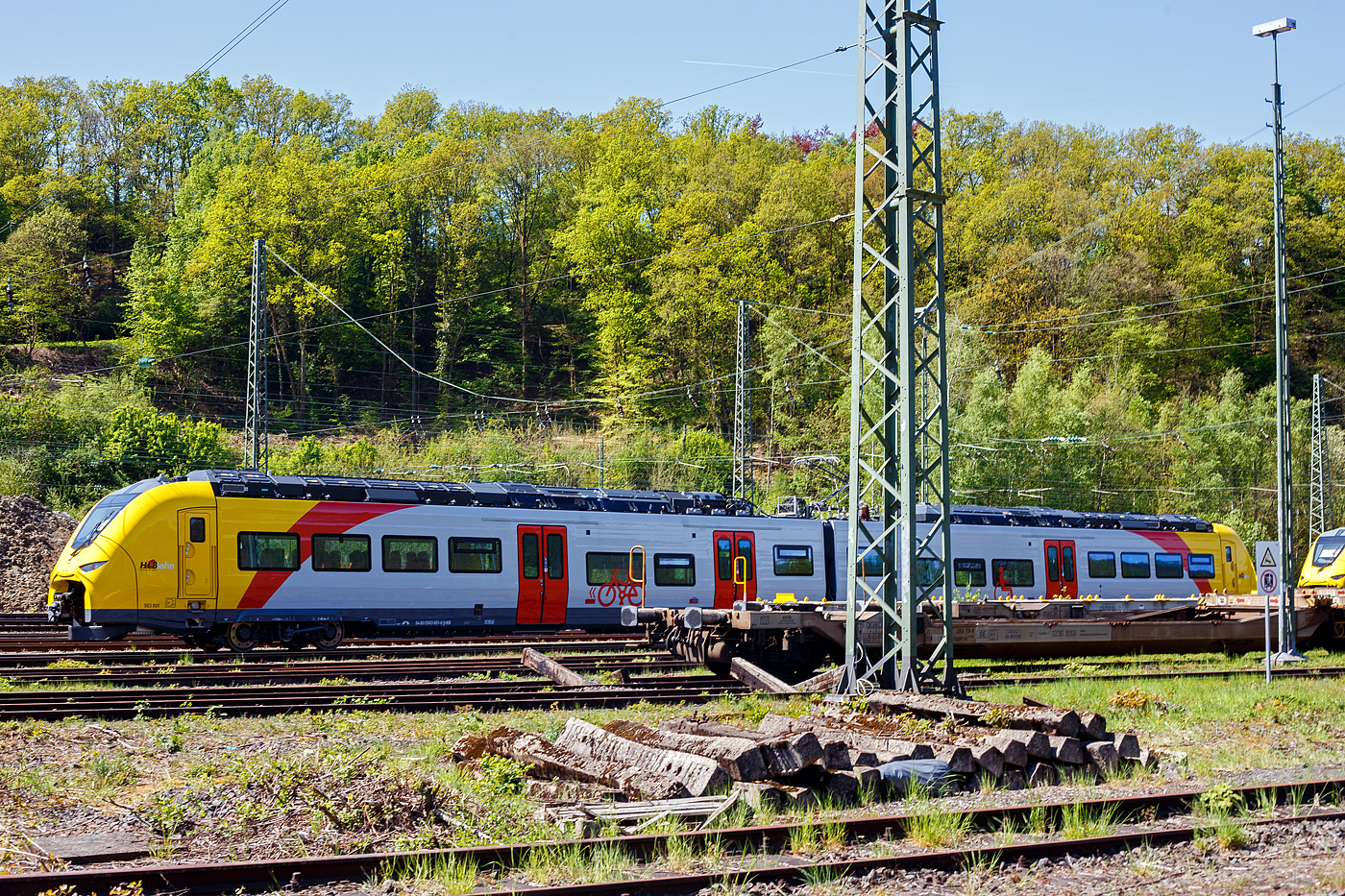 Das ist der neue Klimaschutz am Westerwald....
Zwei der drei neuen zweiteiligen Hybridtriebz�ge (E/Akku) der BR 563 vom Typ SIEMENS Mireo Plus B der HLB (Hessische Landesbahn GmbH) sind am 30 April 2025 in Betzdorf/Sieg abgestellt. Links der 563 801/563 901 (94 80 0563 801-0 D-HEB / 94 80 0563 901-8 D-HEB) und rechts daneben der 563 803/563 903 (94 80 0563 803-6 D-HEB / 94 80 0563 903-4 D-HEB)

Die beiden zweiteiligen SIEMENS Mireo Plus B wurden 2024 von SIEMENS in Krefeld gebaut. 

Auszug aus der Pressemitteilung der HLB:
Alternative Antriebe im Norden von Rheinland-Pfalz: Durchbruch beim Pilotprojekt mit Batteriez�gen im Westerwald / Zuschlag an Siemens Mobility f�r Mireo Plus B Fahrzeuge

Als Aufgabentr�ger f�r den Nahverkehr auf der Schiene im Norden von Rheinland-Pfalz setzt sich der SPNV-Nord gemeinsam mit seinen Projektpartnern von Bund, Land und Eisenbahnverkehrsunternehmen (EVU) f�r den Einsatz von alternativen Antrieben als Abkehr vom Dieselbetrieb ein.

Dabei konnte bereits im letzten Jahr f�r die Beschaffung der Fahrzeuge eine Unterst�tzung aus dem F�rderprogramm des Bundesministeriums f�r Digitales und Verkehr (BMDV) f�r alternative Antriebe gewonnen werden.

Als Besonderheit sollen im SPNV-Nord erstmalig die beiden Antriebstechnologien f�r die Dekarbonisierung des Schienenverkehrs, Wasserstoff und Batterieelektrik, nebeneinander im mehrj�hrigen Fahrgastbetrieb zum Einsatz kommen mit einer vollst�ndigen R�ckfallebene mit Dieselfahrzeugen.

Das betrifft auch den Pilotbetrieb mit drei batterie-elektrischen Fahrzeugen im Westerwald, der zum Fahrplanwechsel im Dezember 2025 geplant ist. Dieser sieht einen Fahrzeugeinsatz auf der RB 90 Limburg – Au – Siegen (Oberwesterwaldbahn und Siegstrecke) und auf der RB 29 Limburg – Siershahn (Unterwesterwaldbahn) durch die Hessische Landesbahn (HLB) vor. Bei diesem Pilotprojekt wurde j�ngst ein wichtiger Durchbruch erzielt:

Als Ergebnis der von der HLB daf�r durchgef�hrten Fahrzeugausschreibung hat Siemens Mobility jetzt den Zuschlag f�r drei zweiteilige Mireo Plus B Batteriez�ge erhalten. Das Fahrzeug mit seiner hohen Antriebsleistung ist f�r den anspruchsvollen Einsatz im Westerwald bestens geeignet. Der geplante Einsatz der drei Batteriez�ge auf den Linien RB 90 und RB 29 umfasst eine Jahresfahrleistung von fast 400.000 Zug-km und ersetzt drei Dieselfahrzeuge. Da die HLB emissionsfreien Bahnstrom bezieht, werden j�hrlich fast 1.150 Tonnen CO2 eingespart. Der Betrieb der Batteriefahrzeuge erfordert keine neue Infrastruktur, denn die Wendezeiten in Limburg von �ber 20 Minuten auf der RB 29 werden f�r die Aufladung der Fahrzeuge ausreichend sein. Bei den auf der RB 90 verkehrenden Batteriefahrzeugen erfolgt dies im elektrifizierten Abschnitt zwischen Au und Siegen. Die Oberwesterwaldbahn (Limburg – Au) ist mit der L�nge von rund 75 km und der zu �berwindende H�he von ca. 350 m derzeit in Deutschland die anspruchsvollste Strecke f�r den vorgesehenen Einsatz von Batteriez�gen.

Die Ausschreibung der Batteriefahrzeuge war so ausgestaltet, dass die Hersteller die M�glichkeit hatten, die Fahrzeuge in laufende Bestellungen zu integrieren, so dass eine schnelle Lieferzeit in Aussicht gestellt wurde.

Siemens Mobility baut f�r den Einsatz im Westerwald drei zweiteilige Mireo Plus B Batteriez�ge, die durch jeweils drei T�ren pro Seite einen schnellen Ein- und Ausstieg erm�glichen. Die Z�ge verf�gen f�r den Betrieb unter Oberleitung und zum Aufladen der Batterien �ber einen Stromabnehmer und verkehren auf den nicht-elektrifizierten Strecken im Batteriebetrieb. Die ger�umigen Fahrzeuge bieten den Fahrg�sten 126 Sitzpl�tze und 156 Stehpl�tze und sind mit einer speziellen Einstiegshilfe ausgestattet, die mobilit�tseingeschr�nkten Menschen das Bahnfahren erleichtert.

Die neuen Batteriez�ge werden auf der Oberwesterwaldbahn Limburg – Altenkirchen - Au - Siegen, und auf der Unterwesterwaldbahn zwischen Limburg – Montabaur – Siershahn unterwegs sein. Die Strecke der OWB betr�gt ca. 115 km, davon sind ca. 75 km ohne Fahrdraht. Es ist vorgesehen die Z�ge in Limburg und auf dem Teilabschnitt Au – Siegen nachzuladen. Auf der UWB betr�gt die nicht elektrifizierte Strecke ca. 35 km. Damit ist ein Zugbetrieb hin und zur�ck ohne Nachladen m�glich. Insgesamt werden die Z�ge �ber 50 Bahnh�fe anfahren.

TECHNISCHE DATEN:
Spurweite: 1.435 mm
Achsfolge: Bo’-2’-Bo’
Fahrzeugl�nge �ber Kupplung: 46.560 mm
Drehzapfenanstand: 2 x 17.930 mm
Anzahl der T�ren je Seite: 3
Installierte Leistung: 1.700 kW
Leistungs�bertragung: elektrisch
Motoren: 2 Drehstrom-Asynchronmotoren
H�chstgeschwindigkeit: 140 km/h 
Kupplung: Mittelpufferkupplung Schaku Typ 10
kleinster befahrbarer Gleisbogen: R 150 m (Normal) / R 100 m (Werkstatt)

Ein kleiner Nachteil gegen�ber den LINT-Dieseltriebz�gen ist mir aufgefallen, die Gesamt-Fensterfl�che ist geringer. Ich bin aber sehr gespannt auf den Betriebseinsatz und wie es l�uft.
