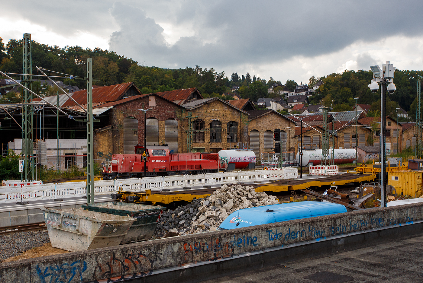 Der 125 t KIROW Gleisbauschienenkran KIROW Multi Tasker KRC 810 T (mit Schwerlastausrüstung), D-HGUI 99 80 9419 024-1, ex 97 82 53 513 19-3, der HERING Bahnbau GmbH (Burbach) ist am 29 September 2025 beim Bahnhof Betzdorf/Sieg im Einsatz, so sind auch hier seine Schutzwagen abgestellt. 

Links die vierachsige (2 x 2-achsige) lange Flachwageneinheit mit abgesenktem Fußboden (ohne Radvorlegern) 27 80 4348 084-9 D-HGUI, der Gattung Laadkks (TWA 850 RV), als Schutzwagen gegenlastseitig. Davor rechts der Schutzwagen auslegerseitig, 37 80 3999 048-6 D-HGUI, der Gattung Res, u.a. beladen mit der Traverse, Anschlagmittel und sonstiges Zubehör).

Die Flachwageneinheit der Gattung Laadkks wurde 1991 von dem sizilianischen Hersteller Keller S.p.A. in Palermo (I) gebaut und an die TRANSWAGGON GmbH (Hamburg) geliefert. 

TECHNISCHE DATEN der Gattung Laadkks:
Gattung: Laadkks (TWA 850 RV)
Spurweite: 1.435 mm (Normalspur)
Anzahl der Achsen: 4 (2 x 2)
Länge über Puffer: 30.980 mm
Ladelänge: 29.740 mm
Ladebreite: 3.100 mm
Fußbodenhöhe über SOK: 850 / 1.000 mm
Höchstgeschwindigkeit: 100 km/h / 120 km/h (leer)
Eigengewicht: 28.100 kg
Nutzlast: 43,9 t ab Streckenklasse B
Achsabstände: 9.000 mm / 6.480 mm / 9.000 mm
Kleinster befahrb. Gleisbogenhalbmesser: 75 m
Bremse: Freno 2x KE-GP-A (LL)
Bremssohle: IB 116
Handbremse: Ja
Intern. Verwendungsfähigkeit: RIV

Hinten am Gleis 105 rangiert die an die HERING Bahnbau GmbH (Burbach) 261 005-3 „Molly“ (92 80 1261 005-3 D-NRAIL), eine Voith Gravita 10 BB der der northrail GmbH (Kiel), mit einen Bauzug der HERING Bahnbau, und macht sich zur Abfahrt in Richtung Köln bereit.