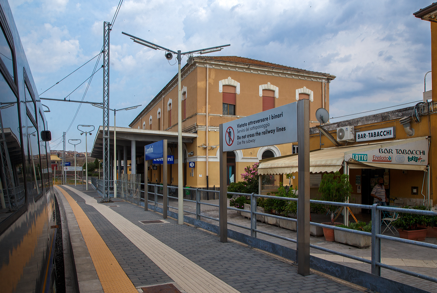 Der Bahnhof Lentini/Sizilien (italienisch Stazione di Lentini/Sicilia) bei km 154,4 an der Bahnstrecke Messina–Syrakus (RFI 152) am 19 Juli 2022.

Der Bahnhof Lentini wurde im Rahmen des Eisenbahnbauprojekts der Gesellschaft Vittorio Emanuele errichtet, welches von der Società per le strade ferrate della Sicilia (Sizilianischen Eisenbahngesellschaft) fortgeführt wurde. Er war Teil des Projekts, die Gegend um Syrakus (Siracusa) per Eisenbahn mit der Stadt und dem Hafen von Catania zu verbinden und landwirtschaftliche Produkte, insbesondere Zitrusfrüchte, aus der Gegend um Lentini und der Ebene von Catania zu den Märkten zu transportieren. Der Bahnhof wurde am nördlichen Stadtrand von Lentini, in der Nähe des Lentini-Sees, errichtet und am 1. Juli 1869 eingeweiht, zeitgleich mit der Eröffnung der Eisenbahnlinie Catania Centrale nach Lentini. Am 19. Januar 1871 wurde er mit der Eröffnung des letzten 57,8 km langen Abschnitts bis zum Bahnhof Syrakus (Siracusa) auch mit Syrakus, im Südosten von Sizilien, verbunden.

Neben den Regionalzüge halten in dem Bahnhof auch Fernverkehrszüge der Gattung Intercity (IC) und Intercity Notte (ICN). 

Ca. 4 km nördlich in Lentini Diramazione zweigt zudem die Bahnstrecke (RFI 154) nach Gela ab.

Merkmale
Der Bahnhof besteht aus einem zweistöckigen Gebäude am südlichen Ende des Gleiskomplexes. Das Bahnhofsgebäude befindet sich westlich der Gleise. Der Bahnhof ist ein Haltepunkt für Personenzüge aller Kategorien.

Der Gleiskomplex umfasst das erste Durchgangsgleis, ein Überholgleis und ein Vorranggleis für den Personenverkehr sowie mehrere Gütergleise. Nur das erste Gleis verfügt über einen Unterstand. Die verschiedenen Güter- und Abstellgleise befinden sich auf der Westseite des Bahnhofs. Früher fuhren viele Güterzüge mit Zitrusfrüchten vom Bahnhof Lentini ab. Seit Ende der 1980er Jahre ist der Verkehr deutlich zurückgegangen.

Am 15. Dezember 2019 weihte der Präsident der Region Sizilien den modernisierten Bahnhof ein. Insbesondere wurde eine Unterführung mit Rampen für Behinderte und neue Bahnsteige errichtet. 

Quellen: Wikipedia (Italien) 
Stand: September 2025
