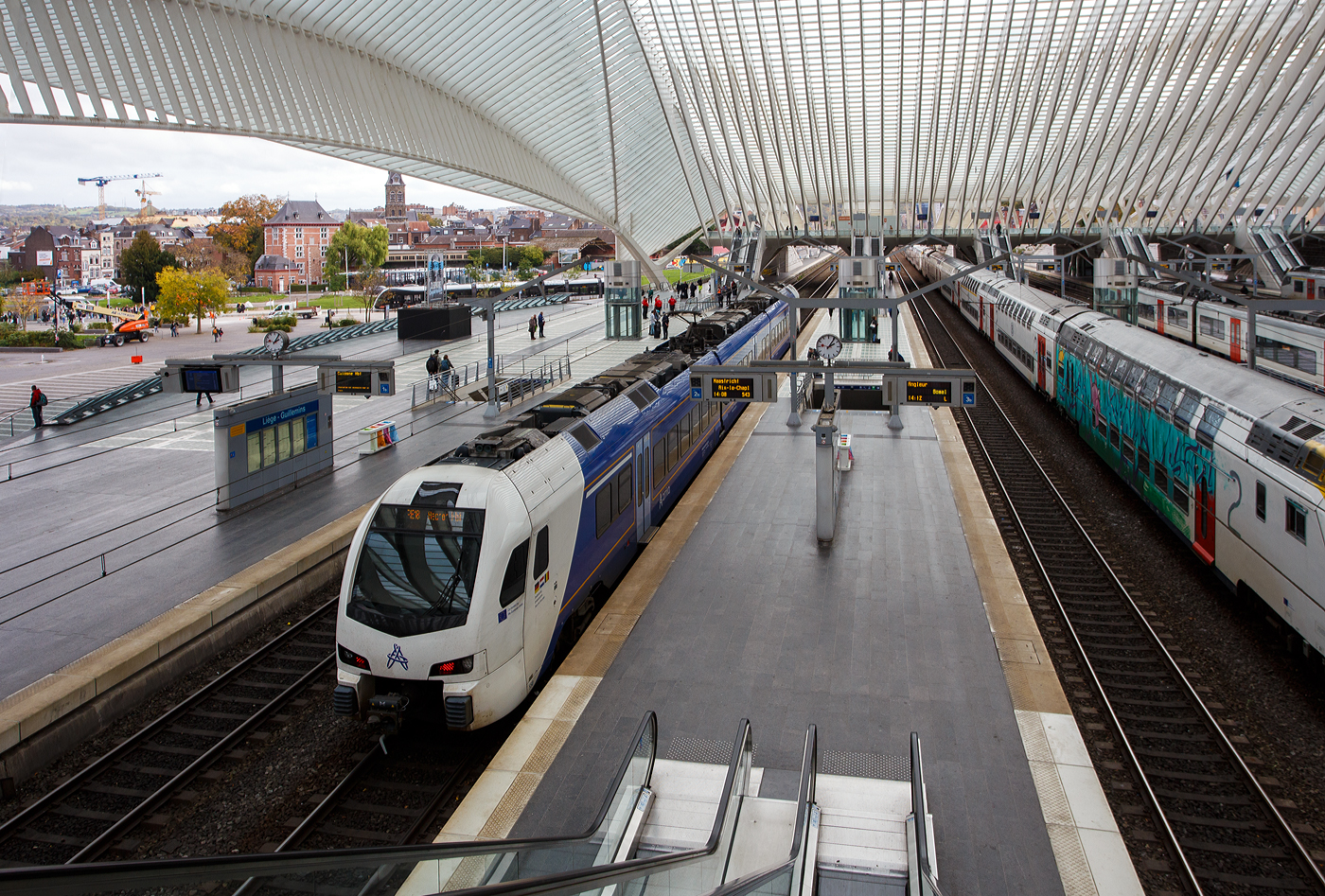Der dreiteilige, 3-System Stadler FLIRT³ Triebzug 550 (94 84 4 040 550-x NL-AN) der Arriva Personenvervoer Nederland steht am 21 Oktober 2025 im Bahnhof Liège Guillemins (Lüttich-Guillemins), als Dreiländerzug / Drielandentrein / Train des trois pays bzw. RE18 / S 43 (LIMAX - Liège-Maastricht-Aachen-Express (Lüttich über Maastricht nach Aachen) zur Abfahrt bereit. 