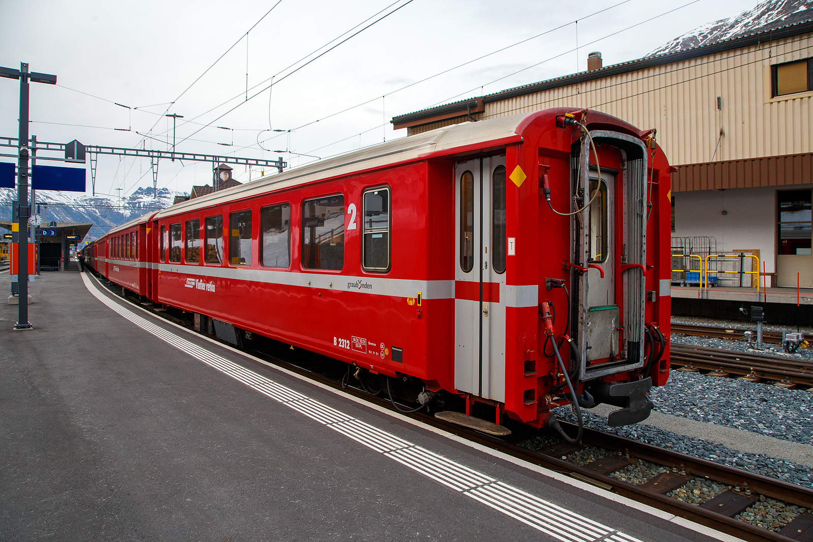 Der fr die Berninabahn verkrzte Einheitswagen I - 2.Klasse Reisezugwagen RhB B 2312 am 21.03.2023 im Zugverband im Bahnhof
Pontresina.

Mit mehr als 100 Fahrzeugen bilden die als Einheitswagen I bezeichneten Personenwagen bis heute die grte Serie im Rollmaterialbestand der RhB. Das Fahrzeugkonzept wurde Anfang der sechziger Jahre in enger Zusammenarbeit zwischen Industrie und RhB entwickelt. Als Neuheit galten damals die Einstiegsbereiche mit WC und Stauraum fr sperriges Gepck an den Wagenbergngen. Folglich weicht das Konzept deutlich von den Mitteleinstiegswagen aus den vierziger Jahren ab.

Die ersten von FFA und SIG gebauten Einheitswagen I wurden Ende 1963 in Betrieb genommen. In einem Zeitraum von etwa zehn Jahren wuchs der Bestand an EW I kontinuierlich. Neben den 18,42 m langen Wagen, die hauptschlich auf dem Stammnetz eingesetzt werden, kamen auch Sonderbauformen mit Aluminiumwagenkasten hinzu. Zu diesen zhlen auch diese auf 14,19 m verkrzten Fahrzeuge fr den Einsatz auf der Berninabahn.

TECHNISCHE DATEN (2.Klasse EW I, verkrzt):
Hersteller Wagenkasten: FFA
Hersteller Drehgestelle: SWP
Inbetriebsetzung: 1968-72
Betriebsnummern: B 2307-2314 und B 2451-2460
Anzahl Fahrzeuge: 18
Spurweite: 1.000 mm
Lnge ber Kupplung:14.910 mm
Breite: 2.650 mm
Achsabstand im Drehgestell: 1.800 mm
Drehzapfenabstand: 9.240
Gewicht: 14.000 kg
Sitzpltze: 50
zul. Hchstgeschwindigkeit: 90 km/h
Lauffhig: StN (Stammnetz) / BB (Berniabahn) / MGB (Matterhorn Gotthard Bahn)
