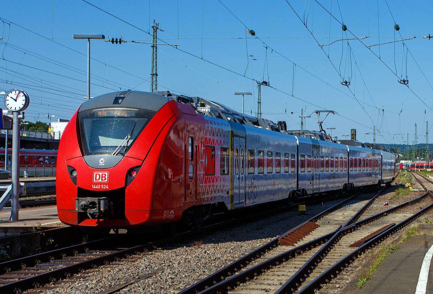 Der für das Elektro-Netz Saar RB (ENS) fahrende Alstom CORADIA Continental 2 „Grinsekatze“ 1440 024 / 1440 524, ein vierteiliger Niederflur-Elektrotriebwagen der DB Regio AG - Region Mitte verlässt, als RB 70 Kaiserslautern - Homburg – Saarbrücken – Merzig, den Hauptbahnhof Kaiserslautern.

Der vierteilige Niederflur-Elektrotriebwagen wurde 2023 von ALSTOM Transport Deutschland GmbH (vormals LHB - Linke-Hofmann-Busch GmbH) in Salzgitter-Watenstedt unter den Fabriknummern 1001514 024 A1, B, C und A2 – 4.

Am 3. Mai 2017 gaben Alstom und die DB Regio AG eine Bestellung über 25 vierteilige Coradia Continental für das Elektro-Netz Saar RB Los 1 auf den Strecken Schweich – Trier Hbf – Saarbrücken Hbf – Kaiserslautern Hbf (ab Dezember 2019) und Trier Hafenstraße – Konz – Saarburg (ab Dezember 2020) bekannt. Die Fahrzeuge besitzen eine Höchstgeschwindigkeit von 160 km/h besitzen. Die Wagenkästen sind in weiß lackiert und Fahrzeugköpfe in Rot. Nachdem seit dem 14. Oktober 2019 ein Probebetrieb mit Fahrgästen (im Rahmen des planmäßigen Verkehrs) stattgefunden hatte, sind die Fahrzeuge seit dem Fahrplanwechsel am 15. Dezember 2019 im regulären Einsatz. Rund 150 Millionen Euro investieren die Aufgabenträger und DB Regio in die Beschaffung der 25 neuen Elektrotriebzüge.

Alstom CORADIA Continental 2 ist ein hochmoderner Elektrotriebzug und die ideale Lösung für den Regionalverkehr. Er ist zuverlässig, schnell und leise und bietet für die Passagiere höchsten Fahrkomfort, inklusive reichlich Platz für Fahrräder (15/Fahrzeug) und Gepäck. Der Coradia Continental erreicht Betriebsgeschwindigkeiten von bis zu 160 km/h und bietet als vierteilige Einheiten 206 Sitzplätze. Verschiedene Mehrzweckbereiche halten ausreichend Platz für Rollstühle, Fahrräder und Kinderwagen bereit. Jedes Fahrzeug besitzt 1 barrierefreie Toilette.Die Antriebsausrüstung der Züge ist auf dem Dach angeordnet, sodass der Innenraum großzügig gestaltet ist, u.a. mit einem breiten und stufenfreien Gang für besseren Fahrgastfluss. Insbesondere wird durch eine angepasste Einstiegshöhe in Verbindung mit zusätzlichen Schiebetritten ein sehr komfortabler Zugang in das Fahrzeug gewährleistet. Der Coradia Continental ist im gesamten Zug mit WLAN, Videoüberwachung sowie Laptopanschlüssen und einem Echtzeit-Fahrgastinformationssystem ausgestattet, das Verbindungsdaten anzeigt. Wir sind auch mit einem gefahren, man reist sehr bequem mit ihm.

Alstoms Coradia Reihe von modularen Zügen profitiert von mehr als 30 Jahren kontinuierlicher Weiterentwicklung und bewährten technischen Lösungen. Bisher wurden mehr als 3.300 Coradia Züge verkauft und rund 2.900 verkehren zurzeit in Dänemark, Frankreich, Deutschland, Italien, Luxemburg, den Niederlanden, Schweden und Kanada

Diese vierteiligen Triebzüge setzen sich auch den folgenden Wagenbaureihen zusammen 1440.0 – 1441.0 – 1441.5 – 1440.5 und sind so 73.300 mm und haben 8 Fahrmotoren. Die Triebzüge haben konventionelle Enddrehgestelle und Jakobs-Drehgestelle zwischen den Mittelwagen

TECHNISCHE DATEN:
Hersteller: Alstom Transport Deutschland GmbH (Salzgitter-Watenstedt)
Baureihe: 1440.0
Art: vierteiliger Niederflur-Elektrotriebwagen
Fahrzeugbestand Elektro-Netz Saar: 25
Spurweite: 1.435 mm (Normalspur)
Achsfolge: Bo’(Bo’)(2’)(Bo’)Bo’ in Klammern Jakobs-Drehgestelle
Länge über Kupplung: 73.300 mm
Drehzapfenabstände: 15.550 mm / 2 x 16.400 mm / 15.550 mm
Achsabstand in den Enddrehgestellen: 2.440 mm
Achsabstand in den Jakobsdrehgestellen: 2.700 mm
Treib- und Laufraddurchmesser: 850 mm (neu) / 780 mm (abgenutzt)
Breite: 2.920 mm
Maximale Höhe (über SO): 4.280 mm
Einstieghöhe (über SO): ca. 600 mm
Eigengewicht: ca. 145 t
Minimaler befahrbarer Gleisbogen Werkstatt/Betrieb: 100/150 m
Stromsystem: 15 kV / 16,7 Hz
Höchstgeschwindigkeit: 160 km/h
Dauerleistung: 2.000 kW
Max. Stundenleistung: 2.880 kW
Fahrgastsitzplätze: 206 (davon 14 in der 1. Klasse)
Niederfluranteil: ca. 89 %
Fahrgasteinstiegstüren je Längsseite: 4
Bremse: KB C-el-pn-R-A-E-Mg (D)
