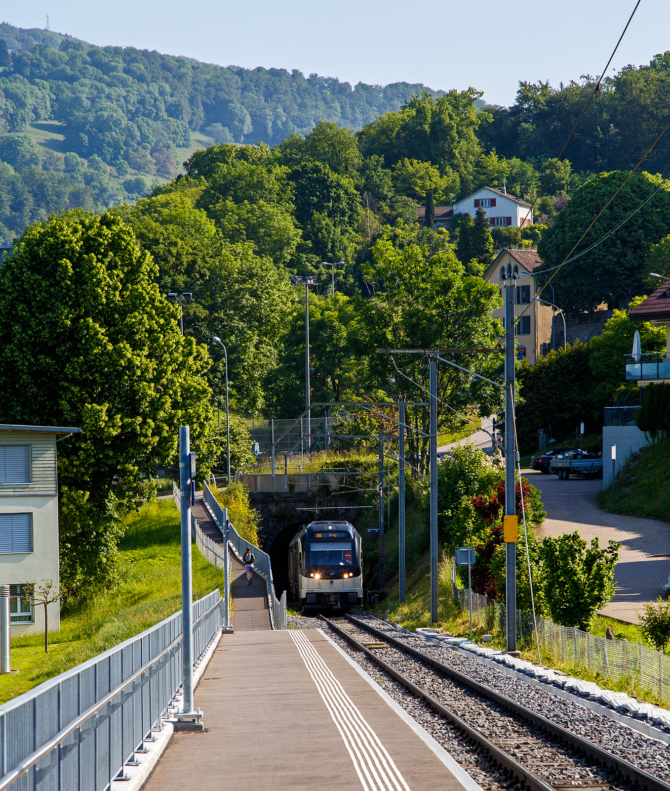 Der MVR (ex CEV) SURF ABeh 2/6 7504  Vevey , als Regionalzug von Vevey nach Blonay, kommt am 27.05.2023 aus dem Tunnel Gilamont und erreicht nun die neue Bedarfshaltestelle Vevey Vignerons. Da wir die Haltewusch-Taste in Richtung Blonay gedrückt haben wird er auch hier halten.