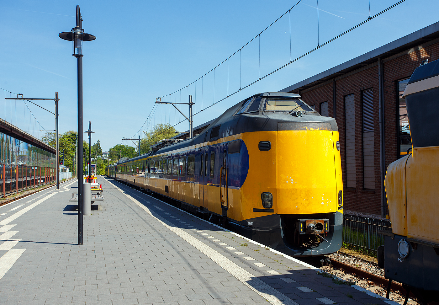 Der NS Koploper ICM 4011 (NL-NS 94 84 4385011-0), ein dreiteilige Elektrotriebwagenzug vom Typ ICM / Plan Z (Koploper), am 29 April 2025 im Het Spoorwegmuseum (bis 2005 NSM - Nederlands Spoorwegmuseum / Niederländischen Eisenbahnmuseum) in Utrecht im Bahnhof Maliebaanstation. Ein sehr schönes Eisenbahnmuseum das zum Verweilen einlädt, leider fehlte uns dieses Mal die Zeit dafür. Übrigens das Gleis 2 (nebenan) ist noch ein aktives Bahngleis, hier fährt stündlich der Pendelzug (als RE) von Utrecht Centraal ein bzw. aus. 

Der Koploper ICM 4011 wurde 1983 von der Waggonfabrik Talbot GmbH & Co. (heute Bombardier) in Aachen (D) für die für die NS - Nederlandse Spoorwegen (Niederländischen Staatsbahnen) gebaut und geliefert. Die Fahrmotoren sind von CEM Oerlikon (Frankreich), und elektrische Installation von Holec (Smit Slikkerveer & Heemaf).

Er war nach den 1977 produzierten sieben Prototypen 1977 (ICM-0), der erste der Serienfertigung (ICM-1). Gegenüber den Prototypen wiesen die Einheiten zahlreiche Verbesserungen (z. B. eine verbesserte Belüftung der Fahrgasträume) auf. Der 4011  Koploper  schied im Mai 2024 aus dem aktiven Dienst bei der NS aus und ging dann ins Museum.

Die ICM (Intercitymaterieel) der NS sind elektrische Triebzüge aus den Jahren 1977 bis 1994 für den Intercity-Verkehr. Mit insgesamt 144 gebauten Einheiten (94 dreiteilige und 50 vierteilige) stellt sie bis heute das Rückgrat des Schnellverkehrs innerhalb der Niederlande dar. 

Volkstümlich werden sie wegen der Wagenübergänge an den Führerstandsenden Koploper (wörtlich «Kopfläufer») genannt. Die Führerstände befinden sich in Panoramakanzeln über dem Übergang, was diesen Wagen ein sehr bulliges Aussehen verleiht. Bis 2005 war es möglich, während der Fahrt von einem Zugteil in den anderen zu wechseln. Die Wagenübergänge an den Endwagen wurden bei der Modernisierung ab 2006 bei allen Zügen entfernt, die beiden Kopftüren wurden durch eine geschlossene Kunststoffplatte (hier gut zuerkennen) ersetzt.

Entwickelt wurden die ICM im Rahmen des «Plans Z» zur Modernisierung des Rollmaterials der NS. Talbot in Aachen produzierte 1977 sieben Prototypen eines dreiteiligen Triebzuges für den schnellen und komfortablen Intercity-Verkehr. Zuerst kamen sie auf der Relation Eindhoven–Venlo zum Einsatz, danach fuhren sie auch zwischen Amsterdam und Nijmegen. Nachträglich erhielten sie die Bezeichnung ICM-0, im Jahr 2003 wurden diese z-gestellt. Die ICM-0 waren noch Wegmann-Drehgestellen ausgestattet.

1983 begann die Serienfertigung des jetzt als ICM-1 bezeichneten Typs. Gegenüber den Prototypen wiesen die Einheiten zahlreiche Verbesserungen auf. Diese erhielten zum Gegensatz der Prototypen nun SIG-Drehgestellen vom Typ GSG 4 (später von RMO Werkspoor in Amsterdam). Ab der Einheit 4051 wurden Choppersteuerungen eingebaut und die Typenbezeichnung änderte sich auf ICM-2. Ab 1990 wurden die ICM als vierteilige Züge (Serien ICM-3 und ICM-4) ausgeliefert, zudem hatte diese nun Magnetschienenbremsen. 

Technik:
Die dreiteiligen Zuggarnituren sind 80,6 m lang und 144 t schwer. Ein Triebzug ist mit 4 Fahrmotoren vom Typ 4 EKO 3250 von TCO - Traction CEM-Oerlikon (Paris, Frankreich) ausgestattet. Später wurden auch Fahrmotoren von Holec vom Typ GT42/30 verbaut. Motor liefert eine Leistung von 315 kW (418 PS) mit
bis zu 2.715 U/min, kurzzeitig ist eine max. Leistung von 344 kW möglich. Insgesamt verfügt ein Triebzug über eine Leistung von 1.260 kW. Die Motoren sind voll gefedert und die Kraftübertragung erfolgt über eine Sécheron-Lamellenkupplung. Der Zug ist für eine Geschwindigkeit von 160 km/h ausgelegt. Der Zug verfügt über 35 Sitzplätze der ersten Klasse und 152 Sitzplätze der zweiten Klasse. Die beiden Kompressoren sind unter dem Fahrgestell untergebracht. Zur Stromversorgung des Steuerstroms und der Beleuchtung dient ein Motorgenerator der unter dem Wagen installiert ist. Dieser wandelt die 1.500 Volt Oberleitungsspannung in 12 Volt Spannung für den Steuerstrom und Beleuchtung um. Der mBDk-Wagen ist mit zwei Stromabnehmern vom Typ AM30 von Faiveley ausgestattet. Um zu verhindern, dass zu viel Strom durch den Zug fließt, sind die Züge mit einem Smit-Schnellschalter ausgestattet. Die Drehgestelle sind SIG - Schweizerische Industrie-Gesellschaft aus Neuhausen am Rheinfall (Schweiz) vom Typ SIG-GSG 4, Triebdrehgestelle haben einen Achsabstand von 2.700 mm und die Laufdrehgestelle von 2.500 mm.

Modernisierung:
Ab November 2006 wurde die Intercity-Ausrüstung der dreiteiligen Züge (Serie 4011–4097) modernisiert. Im April 2007 wurde der erste Triebzug von NedTrain Betriebswerk Haarlem geliefert und in den normalen Regeldienst aufgenommen. Um sie von den noch nicht modernisierten Triebzügen zu unterscheiden, werden die modernisierten Triebzüge als ICMm bezeichnet. Diese Züge wurden komplett saniert und bieten etwa 13 % mehr Sitzplätze. Darüber hinaus unterscheidet sich die erste von der zweiten Klasse klarer: Die erste Klasse hat rote Sitze, die zweite Klasse blaue, wie bei anderen modernisierten Fahrzeugen und neu gebauten Fahrzeugen aus dem Jahr 2006. Darüber hinaus sind die ICMm mit zusätzlichen Einrichtungen wie einer Rollstuhl-Toilette, einer Klimaanlage, Fahrgast-Informations-Displays, einer digitalen Zugzielanzeige und einem statischen Wandler anstelle des bisherigen Motorgenerators ausgestattet. Die Modernisierung der dreiteiligen Triebzüge kostete 190 Millionen Euro.

Die Wagenübergänge an den Endwagen wurden bei dieser Revision bei allen Zügen entfernt. Das Gesamtgewicht eines Triebzuges verringert sich um etwa 1.000 kg (1 t), wenn beide Wagenübergänge durch Kunststoffabdeckplatten ersetzt wurden. Dies wirkt sich positiv auf den Energieverbrauch aus.

Dass die Anzahl der Toiletten halbiert wurde, stieß auf Kritik, auf die die NS aber nicht reagierte.

Der Triebzug 4011 war der erste, der im November 2006 modernisiert wurde und am 16. April 2007 nach Tests in der Klimakammer in Wien sowie einer Reihe von Testfahrten, Kontrollen und Anweisungen an das Personal in Betrieb genommen wurde. Am ersten Betriebstag wurde diese Einheit auf der Intercity-Linie 1500 (Amsterdam – Amersfoort – Deventer) eingesetzt. Der Umbau der dreiteiligen Koplopers (der Serie 40xx) dauerte bis zum 2. Quartal 2010. Der Triebzug 4205 war als erster vierteiliger Triebzug am 22. Februar 2009 in der Werkstatt von Haarlem zur Modernisierung und ging Anfang Januar wieder in Betrieb. Im Februar 2010 wurde mit dem Serienumbau der vierteiligen Triebzüge begonnen. Der letzte ICMm (4240) wurde am 6. Oktober 2011 ausgeliefert.

TECHNISCHE DATEN:
Gebaute Anzahl: 144 (davon 94 dreiteilige ET und 50 vierteilige ET)
Hersteller:Talbot in Aachen (mech. Teil), Oerlikon, Holec (elektr. Ausrüstung)
Baujahre: ab 1977
Spurweite: 	1.435 mm
Achsfolge: Bo'Bo'+2'2'+2'2' (12 Achsen)	 / Bo'Bo'+Bo'2'+2'2'+2'2' (16 Achsen)
Länge über Kupplung: 80.600 mm / 107.100 mm
Achsabstand im Triebdrehgestell: 2.700 mm
Achsabstand im Laufdrehgestell: 2.500 mm
Treibraddurchmesser: 950 mm (neu)
Laufraddurchmesser: 920 mm (neu)
Leergewicht: 144 t / 192 t	
Höchstgeschwindigkeit: 160 km/h 
Motorentyp: 4 bzw. 6 Stück vom Typ 4 EKO 3250 mit je 315 kW (418 PS)
Leistung: 1.260 kW / 1890 kW 
Stromsystem: 1,5 kV Gleichstrom
Kupplung: Scharfenberg
