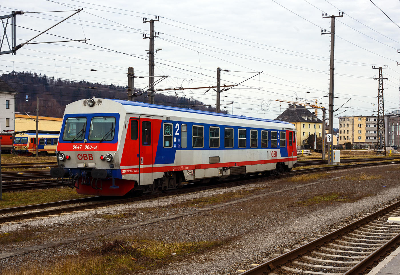 Der ÖBB 5047 060-8 (ÖBB BVT 5047 060-8), ein Dieseltriebwagen vom Typ Jenbacher J3995, rangiert am 14 Januar 2025 im Bahnhof Attnang-Puchheim, hinten steht noch der ÖBB 5047 024-4.

Der Triebwagen 5047 060-8 wurde 1991 von den Jenbacher Werken in Jenbach (Tirol) unter der Fabriknummer J3995-060 gebaut, der 5047 024-4 1989 unter der Fabriknummer J3995-024.

Die Reihe 5047 der Österreichischen Bundesbahnen (ÖBB) sind Dieseltriebwagen die im Regionalverkehr eingesetzt werden. Der Einsatz im Planverkehr begann 1987. Die Triebwagen wurden von den Jenbacher Werken gebaut. Die GySEV Raaberbahn und die Steiermarkbahn besitzen bzw. besaßen ebenfalls Triebwagen dieser Bauart.

Geschichte:
Von den ÖBB wurde 1983 ein Auftrag für sechs neue Dieseltriebwagen nach dem Vorbild der deutschen Baureihe 627 an die Jenbacher Werke vergeben. Das erste Fahrzeug wurde im Juli 1987 fertiggestellt und bei einer internationalen Pressefahrt nach Rosenburg am Kamp präsentiert. Nach erfolgreichem Einsatz auf den Strecken im niederösterreichischen Weinviertel, wo die sechs 5047er in einem rasch konzipierten „Sonderplan“ verwendet wurden, wurden für die ÖBB insgesamt 100 Triebwagen (mit geänderten Wandler-Getriebe) der Reihe 5047 und fünf Doppeltriebwagen-Garnituren der Reihe 5147 gebaut. Der Solo-5047 kostete damals 27 Mio. Schilling, ein Steuerwagen wäre mit 22 Mio. Schilling kaum günstiger gekommen. Daher kam für den 5147 die Lösung als Doppeltriebwagen in Form von zwei kurzgekuppelten Fahrzeugen zum Tragen.

Diese beiden Fahrzeugtypen ersetzten die alten Reihen 5044, 5144, 5145, 5146 und 5081, die teilweise noch aus der Zwischenkriegszeit stammten, technisch veraltet und am Ende ihrer wirtschaftlichen Nutzungsdauer angelangt waren. Im Gegensatz zu lokbespannten Zügen können die Triebwagen im Einmannbetrieb ohne Zugbegleiter (ÖBB-Bezeichnung „0:0“) gefahren und somit Personalkosten reduziert werden, da der Triebfahrzeugführer auch den Fahrscheinverkauf durchführen kann. Später wurden alle Fahrzeuge mit Fahrscheinautomaten ausgestattet, dies macht heute den Fahrscheinverkauf durch den Triebfahrzeugführer obsolet. Mit dem Einsatz dieser Fahrzeuge konnten die ÖBB auf zahlreichen Nebenstrecken eine Verbesserung des wirtschaftlichen Ergebnisses erzielen.

Die Triebwagen 5047 001 bis 032 wurden ab Werk in elfenbein, ultramarinblau und blutorange lackiert, 033 bis 100 in achatgrau, ultramarinblau und verkehrsrot.

Der Erfolg der Triebwagen veranlasste die beiden österreichischen Privatbahnen Steiermärkische Landesbahnen (heute Steiermarkbahn und Bus GmbH) und Raab-Ödenburg-Ebenfurter Eisenbahn (heute GYSEV Raaberbahn AG) ebenfalls zur Anschaffung von je zwei Fahrzeugen dieser Baureihe, die nach ÖBB-Regeln abgenommen wurden. Zum „Kilometerausgleich“ für den Einsatz von ÖBB-Fahrzeugen auf den Privatbahnen kommen diese Triebwagen auch auf ÖBB-Strecken zum Einsatz. Im Unterschied zu den ÖBB-Triebwagen haben die Privatbahnfahrzeuge Rollbandanzeigen an den Fronten.

Weiters beschaffte die NVAG (heute Norddeutsche Eisenbahngesellschaft Niebüll) einen Triebwagen, welcher auf der Strecke Niebüll – Dagebüll im Einsatz steht. Dieser hat eine andere Inneneinrichtung mit erster und zweiter Klasse.

Technik:
Die gesamte Antriebsanlage unterflur angeordnet. Seine Kraft erzeugt der Dieseltriebwagen Reihe 5047 aus einem 12-Zylinder-V-Motor mit Abgasturbolader und Ladeluftkühlung vom Typ MTU 12V183TC12 (Mercedes-Benz OM444) mit 21,93 l Hubraum und einer Leistung von 419kW (570PS). Derselbe Motor ist auch in den Triebwagen DB-Baureihe 628.2 eingebaut. Die Kraftübertragung geschieht über ein Turbogetriebe mit zwei Drehmomentwandlern System Föttinger sowie einer Hydrodynamischen Bremse. Um die Kühlleistung des Getriebeöles zu erhöhen, wird bei der Betätigung der Hydrobremse die Motordrehzahl erhöht. Angetrieben wird das Drehgestell auf der dem Mehrzweckraum abgewandten Seite. Dieses Drehgestell nimmt auch die Magneten für die Indusi bzw. in neuerer Zeit der PZB auf. Am Laufdrehgestell unter dem Mehrzweckraum ist die Magnetschienenbremse befestigt.

TECHNISCHE DATEN:
Spurweite: 1.435 mm (Normalspur)
Achsformel: 2'B'
Länge über Puffer: 25.420 mm
Drehzapfenabstände: 16.600 mm
Achsabstand im Drehgestell: 2.000 mm
Treib- und Laufraddurchmesser: 840 mm (neu)
Eigengewicht: 45 t
Motor: wassergekühlter V12-Zylinder Daimler-Benz Unterflur-Dieselmotor mit Abgasturbolader und Ladeluftkühlung vom Typ DB OM 444 A bzw. MTU 12V183TC12 (der Motor war eine Entwicklung von MB wurde aber von MTU hergestellt).
Motorhubraum: 21,93 Liter
Motorleistung: 419kW (570PS)
Höchstgeschwindigkeit: 120 km/h
Leistungsübertragung: dieselhydraulisch (Turbogetriebe)
Sitzplätze: 68 (in der 2. Klasse)