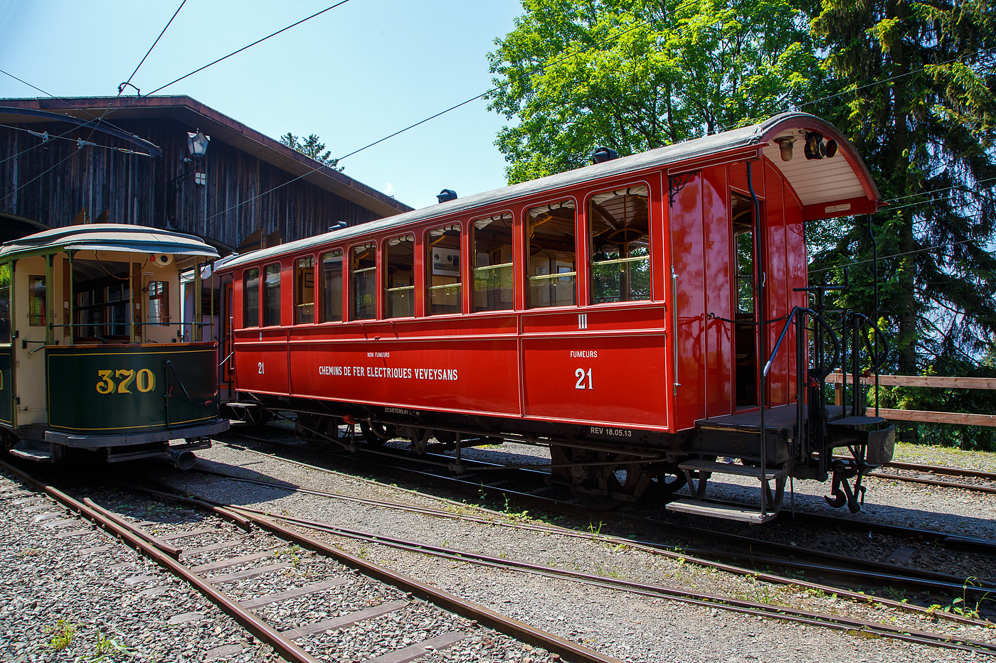 Der sehr schne ex CEV zweiachsige  2. Klasse (Nichtraucher) / 3. Klasse (Raucher) Groraum-Plattformwagen BC 21 der Museumsbahn Blonay-Chamby, ex Chemins de fer Electriques Veveysans - CEV BC 21, am 27.05.2023 im Museum Caulin. 

Der Wagen wurde 1902 von der SWS (Schweizerische Wagons- und Aufzgefabrik AG, Schlieren) fr die Chemins de fer lectriques Veveysans (CEV) gebaut und als CEV BC 21 geliefert. Im Jahr 1971 ging der Wagen an die Museumsbahn Blonay-Chamby.

Die Chemins de fer lectriques Veveysans (CEV) waren eine Schweizer Schmalspurbahngesellschaft, deren Nachfolgegesellschaft die heutige Transports Montreux–Vevey–Riviera (MVR) ist. Sie war (bzw. die MVR ist) der Betreiber der Vevey–Saint-Lgier–Blonay–Les Pliades sowie der Bahnstrecke Blonay–Chamby. Whrend die Bahnstrecke Vevey–Les Pliades ganzjhrig fahrplanmig betrieben wird, dient die Bahnstrecke Blonay–Chamby heute nur in der Sommersaison verkehrenden Zgen der Museumsbahn Blonay–Chamby, sowie gelegentlichen Betriebsfahrten.

TECHNISCHE DATEN:
Baujahr: 1902
Hersteller: SWS (Schweizerische Wagons- und Aufzgefabrik AG, Schlieren)
Spurweite: 1.000 mm (Meterspur)
Achsanzahl: 2
Lnge ber Puffer: 10.200 mm
Lnge Wagenkasten: 9.200 mm (mit Plattformen)
Achsabstand: 5.000 mm
Breite: 2.700 mm
Eigengewicht: 8,6 t
Sitzpltze: 40
