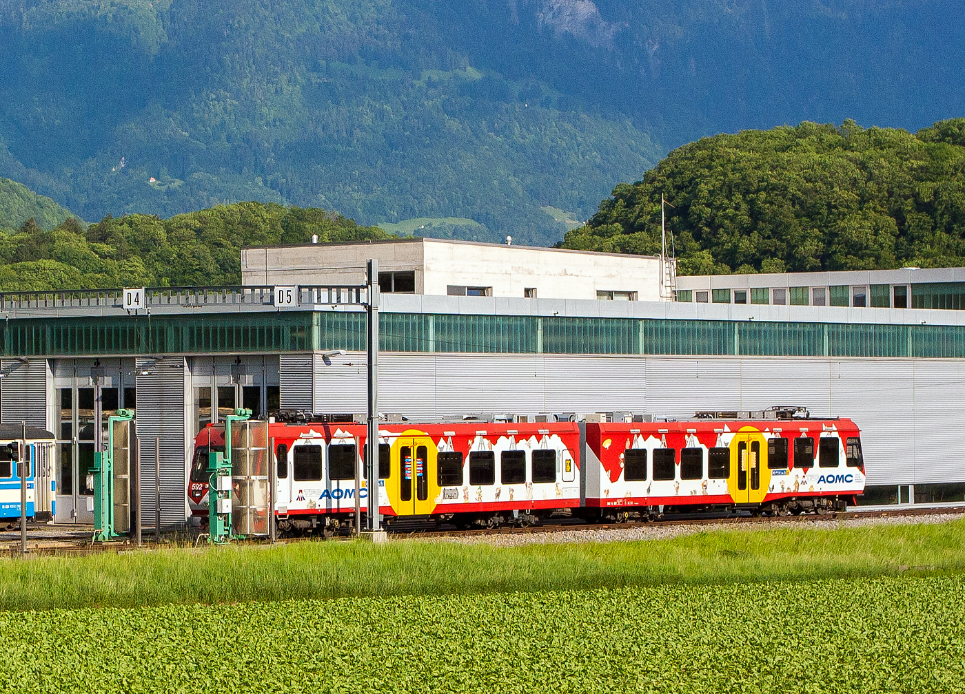 Der tpc AOMC Beh 4/8 592, ein elektrischer Doppeltriebwagen für den gemischten Zahnrad- und Adhäsionsbetrieb, steht am 28 Mai 2012 bei der Waschanlage im Dépôt der tpc in Châlex (bei Aigle). Bild aus einem SBB Zug heraus, die Fenster konnte man noch öffnen. 

Damals vor 11 Jahren war die tpc - Transports Publics du Chablais noch sehr farbenfroh in den ehemaligen Farben der einzelnen vier Bahnen. Der Triebwagen konnte damals auch nur auf der AOMC-Linie fahren, denn er war für 850 V Gleichspannung (DC) und mit dem Zahnstangensystem Strub ausgestattet.

Erst nach der Umstellung der AOMC Strecke im Sommer 2016 auf 1.500 V Gleichspannung (DC) und die Erneuerung der Zahnstangen durch das Zahnstangensystem Abt, wurden die Triebwagen entsprechend umgebaut. So sind sie auch heute auf der ASD Linie zu sehen. Die Bahnen ab Aigle haben heute die gleiche Fahrleitungsspannung 1.500 V und dasselbe Zahnstangensystem  (Abt), die ASD ist ja reine Adhäsionsbahn. Da aber die Zahnstangenabschnitte der AL (Aigle–Leysin-Bahn) bis zu 230 ‰ steil sind, ist der Einsatz bei Ihr in den Zahnstangenabschnitten möglich.
