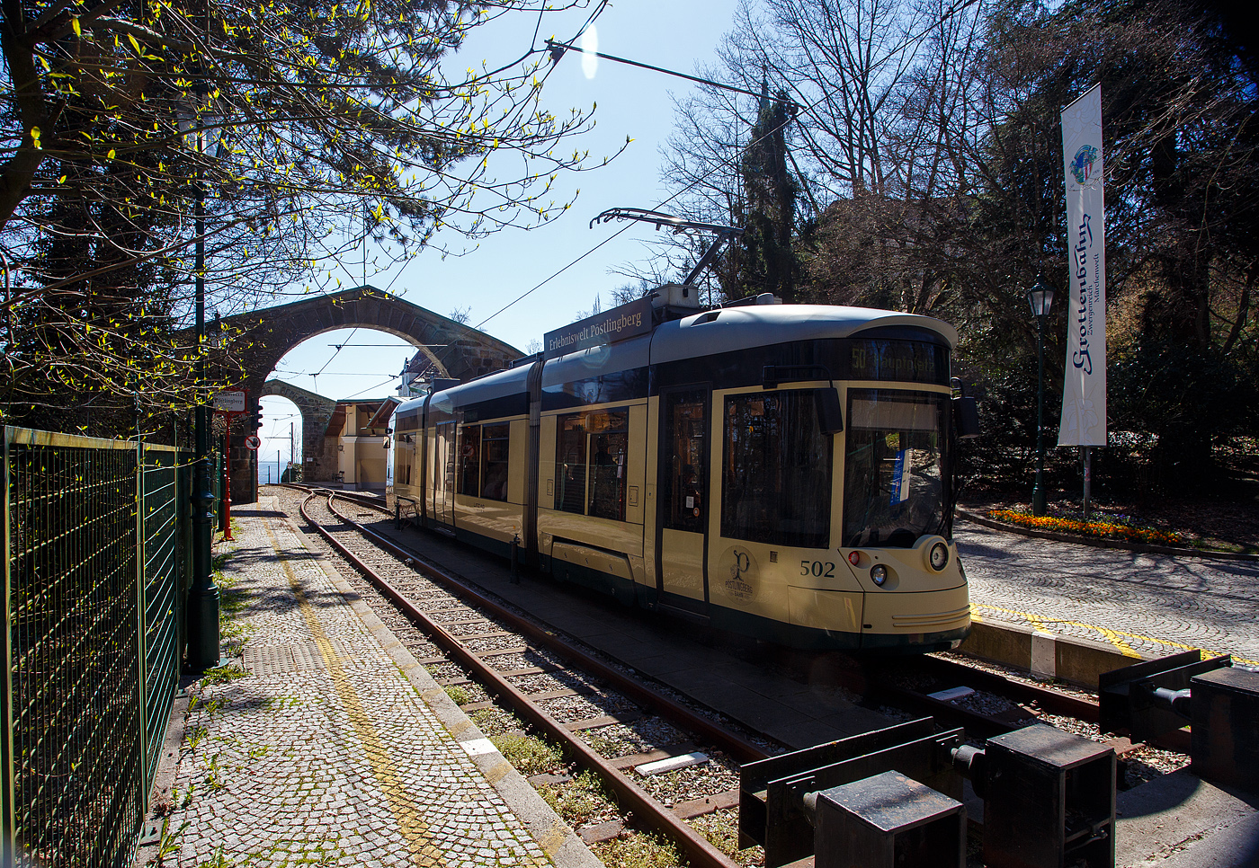 Der Triebwagen 502, ein dreiteiliger vierachsiger Zweirichtungs-Niederflur-Gelenktriebwagen vom Typ Bombardier „Mountainrunner“ hat am 04 April 2025 als Linie 50 (der Linz Linien GmbH) die Bergstation Pöstlingberg (519 m ü.M.) erreicht. Die Pöstlingbergbahn wurde auf 900 mm umgespurt und ist seit 2009 mit dem übrigen Netz der Straßenbahn Linz verknüpft, aber für die Linie braucht man ein separates Ticket.  

Die Pöstlingbergbahn wird, wie das gesamte Straßenbahnnetz, von der Linz Linien GmbH betrieben und gilt, mit einer maximalen Steigung von 116 ‰, als eine der steilsten Adhäsionsbahnen der Welt. Seit 1898 beeindruckt die Linzer Pöstlingbergbahn Gäste aus aller Welt mit ihrer außergewöhnlichen und idyllischen Streckenführung.

Von 2008 bis 2009 wurde die Pöstlingbergbahn revitalisiert und bis zum Hauptplatz verlängert. Trotz massiver Umbau- und Erneuerungsarbeiten blieb die „alte“ Streckenführung erhalten und der ursprüngliche Charakter der Bergbahn wurde bewahrt. Auch die typische eingleisige Streckenführung zwischen den Haltestellen „Landgutstraße“ und „Pöstlingberg“ mit den drei Ausweichstellen blieb unverändert. Die alten Wartehütten wurden wieder originalgetreu aus Holz nachgebaut.

Pünktlich zum 111-Jahre-Jubiläum wurde die Bahn nach den Umbauarbeiten am 29. Mai 2009 wieder eröffnet. Die sanfte Revitalisierung brachte für die Fahrgäste eine deutliche Verbesserung von Komfort, Sicherheit und Barrierefreiheit. Die neuen Niederflurwagen wurden dem Aussehen der alten Wagen nachempfunden. Im Gegensatz zu den historischen Wagen können nun auch Fahrgäste mit eingeschränkter Mobilität die Pöstlingbergbahn problemlos nutzen. Leider verkehrt an Werktagen nur im 30-Minuten-Interval, daher kann es bei schönem Wetter vorkommen das die Triebwagen überfüllt sind. 

Bei einer Streckenlänge von 4,14 km überwindet die Pöstlingbergbahn einen Höhenunterschied von 255 Meter in 20 Minuten, wobei die eigentliche 2,88 km lange Bergstrecke beim Bahnhof Urfahr beginnt. Hier befindet sich auch die ehemalige Talstation. Die Spurbreite wurde zwischen 2008 bis 2009 von 1.000 mm auf 900 mm angepasst. So ist eine Fahrt im Netz der LINZ AG LINIEN problemlos möglich und die Verlängerung bis zur neuen Talstation
„Hauptplatz“ ein weiterer Beitrag zur Attraktivierung der Pöstlingbergbahn. Denn nun ist der Start- und Zielpunkt mitten im Herzen von Linz und speziell für Touristen leicht zu erreichen. 

Fuhrpark:
Als Fahrzeuge kommen vier als „Mountainrunner“ bezeichnete Niederflurfahrzeuge aus der Familie der Bombardier Cityrunner zum Einsatz, die 2009 (TW 501 bis 503) und 2011 (TW 504) von Bombardier in Wieng ebaut wurden. Außerdem wurden die drei Fahrzeuge VIII, X, XI des historischen Fahrzeugsbestands von Meterspur auf 900 mm umgebaut und finden ebenfalls Verwendung.

Die Niederflur-Gelenktriebwagen vom Typ Bombardier „Mountainrunner“ sind dreiteilige vierachsige Zweirichtungs-Niederflur-Gelenktriebwagen. Die Triebwagen wurden in einem „Retro-Design“ gestaltet. Anders als andere Cityrunner besitzen die Linzer Fahrzeuge (auch die der Straßenbahn) durchgehende Radsatzwellen (konventionelle Drehgestelle) und längs an den Seiten angeordneten Motore. Lediglich die Laufwerksrahmen sind dabei noch im Wesentlichen baugleich. Aufgrund der durchgehenden Radsatzwellen musste der Fußboden im Laufwerksbereich auf 450 mm über der Schienenoberkante angehoben werden. Zur sonstigen Bodenhöhe von 365 mm und der Einstiegshöhe von 320 mm gibt es jedoch keine Stufen, sondern Rampen mit einer Neigung von 6 %. Jeder Endfahrzeugkasten ruht auf einem Drehgestell, das Mittelteil als Sänfte ausgeführt. Als Bremsen kommen statt der „früheren“ Zangenbremsen nun Magnetschienenbremsen zum Einsatz.

TECHNISCHE DATEN:
Spurweite: 900 mm 
Achsformel: Bo’Bo’
Länge über Alles: 19.160 mm
Breite: 2.400 mm
Kleinster Halbmesser: 43 m 
Leergewicht: 28.000 kg
Dienstgewicht: 35.000 kg
Höchstgeschwindigkeit: 50 km/h (Ebene) / 25 km auf Bergstrecke
Leistung: 4 x 143 PS (4 x 105 kW)
Motore: 4 Stück luftgekühlten Drehstrom Asynchronmotoren 
Maximale Steigung: 11,6 %
Fahrdrahtspannung: 600 Volt DC
Anzahl Sitzplätze: 33
Anzahl Stehplätze: 55
