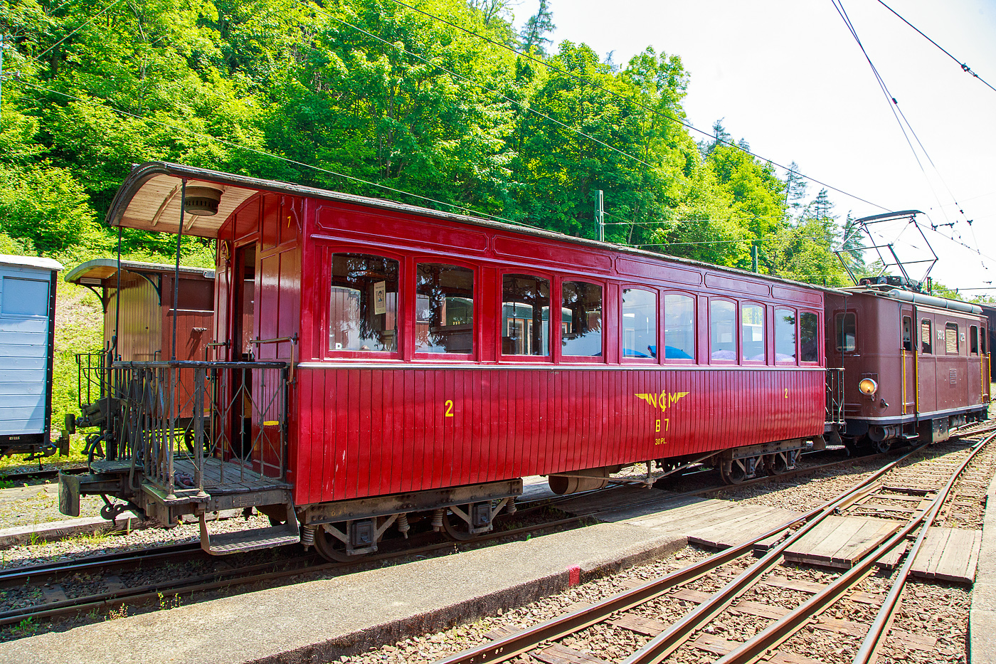 Der vierachsige 3.Klasse Großraum-Plattformwagen C4 7 der Museumsbahn Blonay-Chamby (beschriftet jedoch als B 7), ex NStCM C 7, am 27.05.2023 im Museumsareal in Chaulin. der Museumsbahn Blonay-Chamby. 

Der Wagen wurde 1910 für die französische Chemins de Fer de Haute Saône vom Hersteller Ateliers de construction du Nord de la France (ANF Blanc-Misseron) als Salonwagen A7 gebaut. 1934wurde er von der Le Morez - La Cure (MLC) gemietet und 1938 endgültig gekauft. Im Jahr 1946 übernahm ihn die Chemin de fer Nyon–St-Cergue–Morez (NStCM), die Polstersitze wurden durch Holzbänke ersetzt und der Wagen wurde zum C 7. Die Museumsbahn Blonay-Chamby konnte den Wagen 1993 erwerben.

TECHNISCHE DATEN:
Baujahr: 1910
Hersteller: ANF Blanc-Misseron
Spurweite: 1.000 mm (Meterspur)
Achsanzahl: 4
Länge über Puffer: 10.940 mm
Länge Wagenkasten: 10.000 mm (mit Plattformen)
Drehzapfenabstand: 5.600 mm
Achsabstand im Drehgestell: 1.240 mm
Eigengewicht: 8,5 t
Sitzplätze: 30