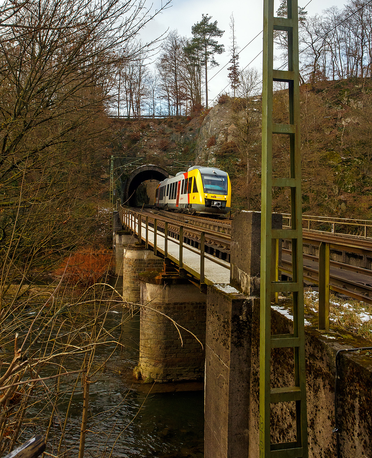 Der VT 256 (95 80 0648 156-7 D-HEB / 95 80 0648 656-6 D-HEB), ein Alstom Coradia LINT 41 der HLB - Hessische Landesbahn (3LänderBahn), hat als RB 90 „Westerwald-Sieg-Bahn“ , der Verbindung Altenkirchen(Westerwald) – Au(Sieg) - Betzdorf(Sieg) – Siegen Hbf, auf der Siegstrecke (KBS 460) bei km 79,4 den 32 m langen Mühlburg-Tunnel und fährt nun auf die Siegbrücke und erreicht bald den Bahnhof Scheuerfeld (Sieg) am 02.12.2023.

Durch eine Weichenstörung beim Bahnhof Scheuerfeld, die schnell behoben wurde, fährt er hier heute mal links.