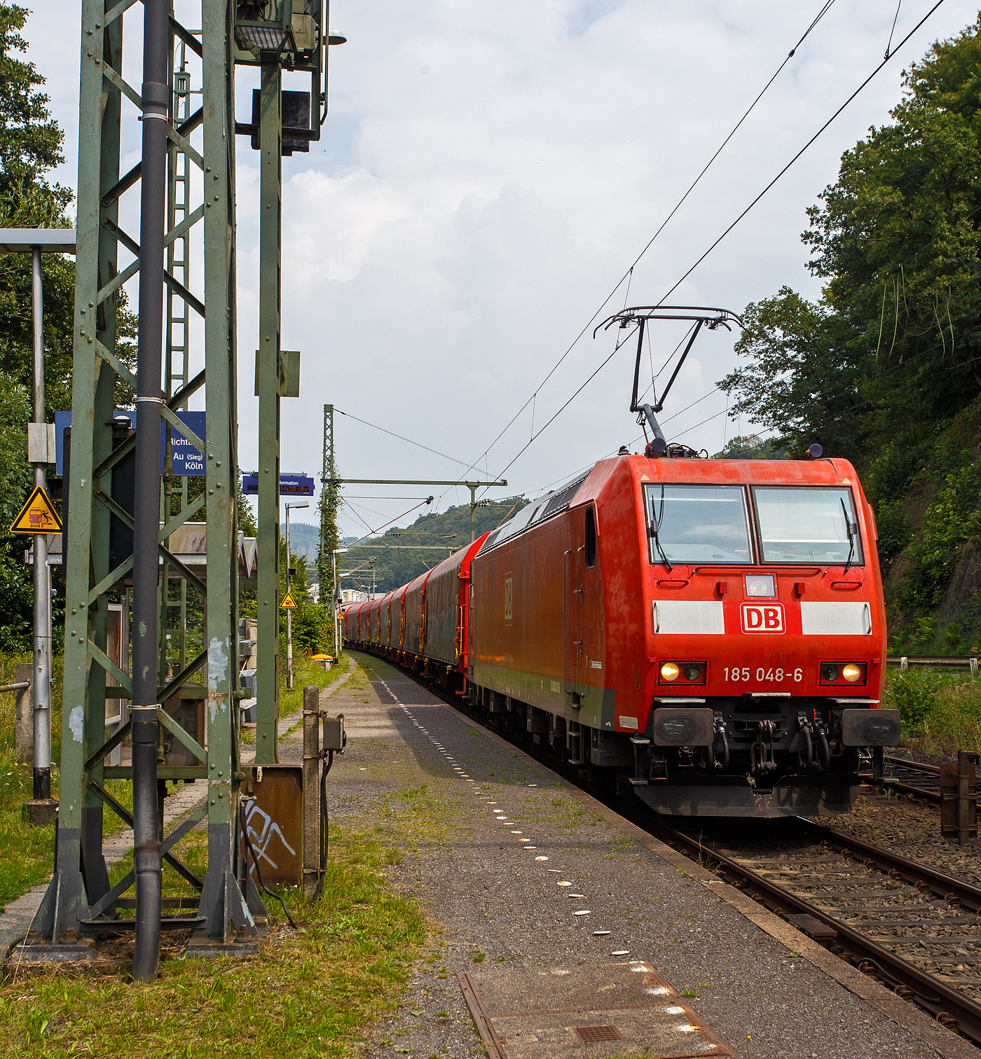 Die 185 048-6 (91 80 6185 048-6 D-DB) der DB Cargo fährt am 03 August  2024 mit einem leeren Coilzug durch Scheuerfeld (Sieg) in Richtung Köln. 

Die TRAXX F140 AC1 wurde 2001 von ABB Daimler-Benz Transportation GmbH, (Adtranz) in Kassel unter der Fabriknummer 33447 gebaut. Sie hat die Zulassungen für Deutschland und Österreich.
