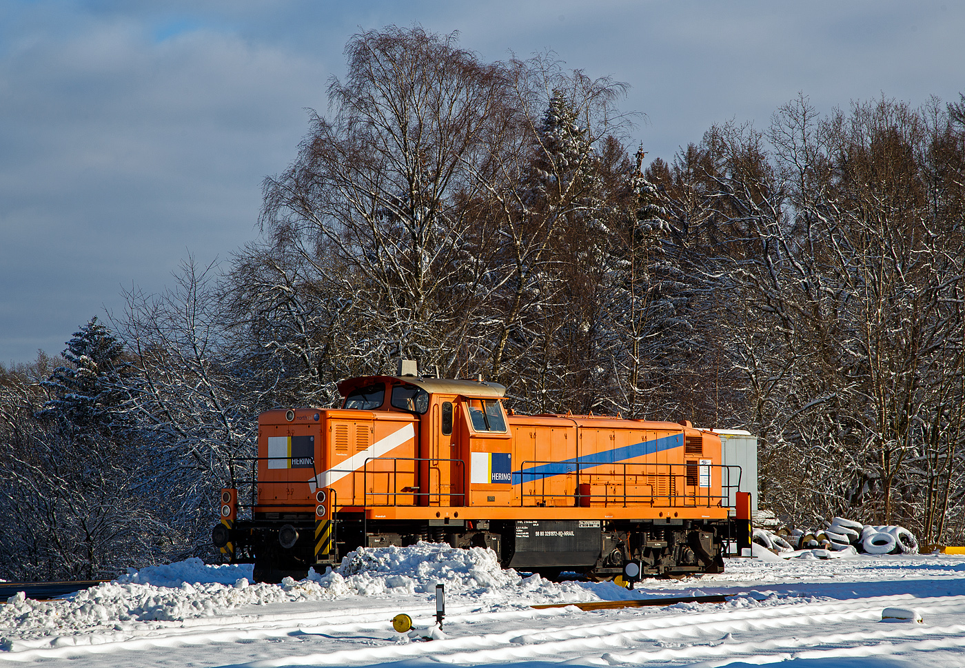 Die an die Hering Bau GmbH & Co. KG (Burbach) vermietete 291 972-8 (98 80 3291 972-8 D-NRAIL) eine Sonderbauart MaK G 1600 BB der Northrail (Hamburg) ist am 09 Januar 2021 auf dem Betriebshof der Westerwaldbahn auf der Bindweide bei Steinebach/Sieg.

Die MaK G1600 BB der Sonderbauart wurde 1971 von MaK Maschinenbau GmbH im Werk MaK-Kiel-Friedrichsort unter der Fabriknummer 1000516 für die Bayerische Braunkohlen-Industrie AG (BBI AG) in Schwandorf gebaut und als M 19 geliefert.
Die BBI AG hatte eine eigene Werksbahn womit die Braunkohle vom Abbau bei Wackersdorf ins sieben Kilometer entfernte Kohlekraftwerk Schwandorf transportiert wurde. Im Jahr 1981 wurden hier täglich zwischen 20.000 und 25.000 Tonnen Kohle verfeuert.
Weiterer Lebenslauf der 291 972-8:
1982 ging die BBI AG in die Bayernwerk AG (BAG) über
1986  Ausbau der Hagenuk Dampfheizkesselanlage
2000 Bayernwerk wurde nun e.on Kraftwerke GmbH
2002 wurde die Lok an die OHE - Osthannoversche Eisenbahnen AG, in Celle verkauft und fuhr nun als OHE 120076. 
2007 erhielt die NVR-Nummer 98 80 3291 972-8 D-OHE
2011 ging die Lok an die northrail GmbH in Hamburg, wo sie seitdem als Mietlok unter der UIC-Nummer 98 80 3291 972-8 D-NTS fährt

Technik:
Die MaK G 1600 BB ist eine dieselhydraulische Lokomotive, von denen 16 Stück (mit 1.600 PS), sowie 3 Stück in Sonderbauart (mit 1.000 PS), zwischen 1971 und 1979 von der Firma MaK Maschinenbau GmbH, Werk MaK-Kiel-Friedrichsort, gebaut wurden. Zu der Sonderbauart gehört auch diese Lok hier.

Analog zur G 1300 BB wurde auch aus der an die DB gelieferten V 90 eine Privatbahnversion entwickelt, die in fünf Exemplaren als V 90 P gebaut wurde und im Wesentlich der DB-Variante entsprach, jedoch einen hauseigenen Motor erhielt. Nachdem sich jedoch weniger die Privatbahnen als vielmehr die DB selbst für diese Loks interessierten, entstand bei MaK eine weitere Variante der V 90, die spezieller auf die Bedürfnisse der Privatbahnen abzielte und z.B. eine 24V-Elektrik erhielt. Diese unterscheidet sich auch deutlich in ihren Hauptabmessungen von den DB-Maschinen. Ein wenig sieht man der Lok die Verwandschaft mit der V 90 an.

Der eingebaute Achtzylinder-Motor des Typs MaK 8M282AK leistet 1.180 kW (1.600 PS) bei 1.000 U/min, die Lok erreicht je nach Getriebeeinstellung eine Höchstgeschwindigkeit von 44 bis 80 km/h. Das Dienstgewicht liegt je nach Ausrüstung zwischen 80 und 104 Tonnen. Bei den Lokomotiven mit einer Höchstgeschwindigkeit von 44 km/h entfällt der Streckengang.

Sonderbauart der MaK  G 1600 BB (wie diese Lok):
Für den Einsatz vor Kohlezügen in Tagebauen benötigte die Bayerische Braunkohlen-Industrie (BBI) Loks mit eingebauter Dampfheizung. Eine Leistung von 1.100 PS wurde dabei als ausreichend erachtet.
So wurden 1971 und 1972 von MaK für die BBI 3 Lokomotiven in Sonderbauart gebaut. Um ausreichend Platz für den Hagenuk Dampfheizkesselanlage  zu haben, wurden Fahrwerk und Aufbauten von der G 1600 BB übernommen. Die Antriebstechnik wurde der G 1100 BB, einem Sechszylinder-MaK-Dieselmotor mit Turbolader und Ladeluftkühlung vom Typ 6M282 AK mit 1.100 PS) übernommen. Der zusätzlich gewonnene Platz, durch Verlagerung des Druckluftgerüstes unter das Führerhaus, konnte für den Einbau des Heizkessels genutzt werden, welcher mittlerweile entfernt worden ist. Äußerlich waren die Loks an dem zweiten Auspuff (für die Dampfheizkesselanlage) auf der Führerhausrückseite und dem kleineren Kühler, der der geringeren Leistung angepasst wurde erkennbar.  Die Loks wurden vom Hersteller verwirrenderweise ebenfalls als G 1600 BB bezeichnet. Da der Dampfheizung ausgebaut wurde, entfiel auch der zweite Auspuff.

.TECHNISCHE DATEN der G1600 BB in Sonderbauart:
Gebaute Stückzahl: 3  (und 16 Standardloks)
Spurweite: 1.435 mm (Normalspur)
Achsformel: B'B'
Länge über Puffer: 14.320 mm
Drehzapfenabstand: 7.000 mm
Achsstand im Drehgestell: 2.500 mm
Treibraddurchmesser:  1.100 mm (neu)
Höhe: 4.200 mm
Dienstgewicht: 80 t
Radsatzfahrmasse: 20 t 
Kleinster bef. Halbmesser:  60 m
Höchstgeschwindigkeit: 48 km/h (Rangiergang) / 74 km/h (Schnellgang)
Dieselmotor:  MaK 6-Zylinder Reihenmotor mit Abgasturbolader und Ladeluftkühlung vom Typ vom Typ 6M282 AK
Installierte Leistung: 809 kW (1.100 PS)
Nenndrehzahl: 1.000 U/min
Anfahrzugkraft: 265kN 
Tankvolumen: 3.500 l
Funkfernsteuerung: Theimeg EC/LO
Bremse: KE-GP2mZ

Quellen: Northrail, loks-aus-kiel.de, wikipedia.org
