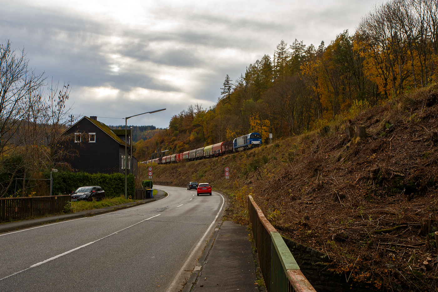 Die an die KSW vermietete 272 409-4 / D21 (92 80 1272 409-4 D-BE) der Bentheimer Eisenbahn, ex Rurtalbahn V 204 (92 80 1272 409-4 D-RTBC), eine Vossloh G 2000 BB (mit symmetrischem Führerhaus), fährt am 31 Oktober 2025, von Betzdorf kommend, mit ihrem Coilzug zwischen Sassenroth und Herdorf in Richtung Bahnhof Herdorf bzw. KSW Rbf Herdorf (Betriebsstätte Freien Grunder Eisenbahn).