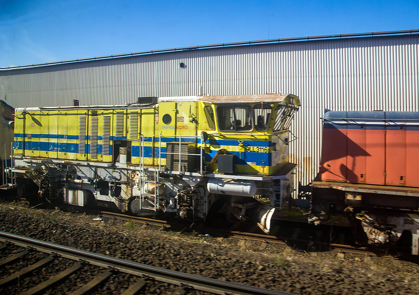 Die DLL 3116 (92 74 2003 116-7)  der InfraNord AB, ex SJ Tc 295, steht am 22 Mrz 2019 bei Nssj (Schweden). Die Aufnahme konnte ich aus einem fahrenden Zug machen.

Lebenslauf des Fahrzeugs:
Die Diesellok (mit Schneepflug) wurde 1969 von NOHAB (Nydqvist & Holm AB - Bofors-Nohab AB) in Trollhttan (Schweden) unter der Fabriknummer 2754 gebaut und als Tc 295 an die SJ geliefert. Die Gesellschaft InfraNord kaufte im Laufe der 2000er Jahre drei Fahrzeuge von Banverket, dazu gehrte u.a. die ehemalige Tc 295 (DLL 3116).

1969 bis 1984 - Tc 295 der SJ - Statens Jrnvgar
1984 bis 1989 - Qaz 945 1 151 - Bahndienstfahrzeug (Qaz) der SJ
1989 bis 1992 - BV MTC011 3116 der Banverket
1992 bis 200x - BV DLL 3116 der Banverket 
Seit 200x dann an InfraNord - DLL 3116 (92 74 2003 116-7)

Nachdem alle 1984 vorhandenen Fahrzeuge von Statens Jrnvgar als Bahndienstfahrzeuge (Qaz) eingestuft wurden, wurde 1986 die gesamte Baureihe wieder als SJ Tc bezeichnet. Mit der 1988 erfolgten Grndung von Banverket (BV) wurden die Aufgaben fr die Lokomotiven an BV abgegeben. Einige Lokomotiven wurden 1989 erneut noch von SJ mit einer neuen Inventarnummer fr Bahndienstfahrzeuge (Qzx) versehen, jedoch wurde bereits 1988 mit der bernahme der Fahrzeuge von BV begonnen, die 1989 abgeschlossen wurde. 1992 erhielten sie die Baureihenbezeichnung DLL (schwedisch diesellinjelok).

Die Baureihe Tc:
Die Fahrzeuge der schwedischen Baureihe Tc wurden von Statens Jrnvgar (SJ) 1969 (Tc 294 und 295), 1970 (Tc 296–311) und 1971 (Tc 312 und 313) gekauft. Die Lokomotiven wurden fr die Befrderung von Gter- und Arbeitszgen sowie fr Schneerumdienste verwendet. Ab 1969 ersetzte die SJ - Statens Jrnvger in grerem Umfang Schneepflge, die von Lokomotiven befrdert werden mussten. Neben den 20 leichteren Lokomotiven der Baureihe Tc mit der Achsfolge B wurden 10 schwere Lokomotiven mit der Achsfolge Bo’Bo’ beschafft, die die Baureihenbezeichnung Tb erhielten. Ab 1984 wurden die Lokomotiven aus dem Gterzugdienst herausgelst und nur noch als Bahndienstfahrzeuge verwendet, 1988 an Banverket bertragen und dort fr Sonderaufgaben eingesetzt.

Die Lokomotiven hatten vorne fest montierte und an den Seiten ausklappbare Schneerumer, mit denen eine Rumbreite von 6,40 m erreicht werden konnte. Da sie nur einen Fhrerstand hatten, mussten sie mit einer eingebauten Hubeinrichtung gedreht werden. Mehrfachtraktion war mglich, indem zwei Lokomotiven mit den B-Enden  (den Seiten ohne Fhrerstand)  gekuppelt wurden. Bei Bedarf konnte der vorne angebrachte Schneepflug entfernt und Rangiertritte sowie Puffer und Kupplungseinrichtung montiert werden, um fr Gleisbauzge universeller einsetzbar zu sein.

TECHNISCHE DATEN:
Gebaute Anzahl: 20
Ursprngliche Nummerierung: Tc 294-313
Hersteller: NOHAB
Baujahre: 1969 bis 1971
Spurweite: 1.435 mm (Normalspur)
Achsfolge:  B
Lnge ber Puffer: 12.370 mm (mit Pflug13.900 mm)
Dienstgewicht: 33,4 t (mit Pflgen 36 t)
Motor: (KHD) Deutz wassergekhlter 12-Zylinder –Viertakt-Dieselmotor mit Abgasturboaufladung und Ladeluftkhlung vom Typ BF12M716
Dauerleistung: 450 kW (612 PS)
Kraftbertragung: Dieselhydraulisch
Getriebe: Voith T420r 
Anfahrzugkraft: 90 kN
Hchstgeschwindigkeit: 90 km/h
