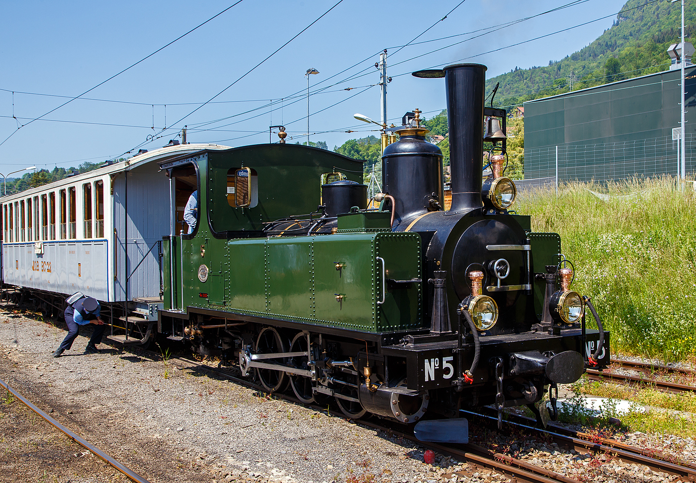 Die kleine aber schöne  ex LEB G 3/3 Nr. 5  Bercher  (Lausanne–Echallens–Bercher-Bahn) der Museumsbahn Blonay–Chamby (BC) steht am 27 Mai 2023 in Blonay mit ihrem Zug zur Abfahrt zum Museum Chaulin bereit.

Die LEB G 3/3 Nr. 5  Bercher ) wurde 1890 von der Elsässische Maschinenbau-Gesellschaft Grafenstaden (später Société Alsacienne de Constructions Mécaniques) unter der Fabriknummer 4172 gebaut und an die Lausanne–Echallens–Bercher-Bahn geliefert. Die EMBG hatte auch zwei Jahre zuvor die baugleiche Nr. 2 geliefert. Die beiden dreiachsigen Tenderlokomotiven trugen die Hauptlast des Verkehrs, bis in den Jahren 1903 und 1905 zwei baugleichen Tenderlokomotiven, die G 3/3 6 „Gros-de-Vaud“ und G 3/3 7 „Talent“ durch die Schweizerische Lokomotiv- und Maschinenfabrik (SLM) in Winterthur abgeliefert wurden. 

Von der YSteC konnte die LEB 1920/1921 die drei 1893 ebenfalls durch die EMBG gebauten Mallet-Lokomotiven G 2x2/2 Nr. 1 bis 3 gebraucht übernehmen. Nun waren die G 3/3 Nr. 2 und 5 nicht mehr gefragt. Während die G 3/3 2 „Échallens“ bereits 1929 verschrottet wurde (seit 1920 war sie bereits abgestellt), die G 3/3 Nr. 5  Bercher  hatte es da etwas besser, sie wurde 1934 an die Firma Energie de l’Ouest Suisse (EOS) für die Baustelle der Staumauer Grande-Dixence verkauf. Nach dem die Arbeiten 1935 erledigt sind geht sie bei der EOS außer Betrieb. Im Jahr 1939 verlässt die Schweiz und geht nach Vorarlberg in Österreich, zu einer Baufirma. Die Baufirma verschenkte 1967 die Lok und sie wurde, wie viele andere Dampflokomotiven zu dieser Zeit, auf einem Kinderspielplatz in der Stadt Feldkirch aufgestellt. Das Ausstellungsobjekt weckte die Aufmerksamkeit einiger Mitarbeiter der Museumsbahn Blonay–Chamby (BC), denen es gelang 1973 diese Lokomotive im Tausch gegen eine andere Lok zu erwerben.

Nach einer Aufarbeitung war die Lokomotive 1985 bis 2005 in Betrieb. Dann musste sie abgestellt werden. 2013/2014 wurde die Lokomotive ein zweites Mal durch die Museumseisenbahner aufgearbeitet. Seit dem Frühling 2015 ist die zweitälteste Schmalspur-Dampflokomotive der Schweiz, die älteste ist die G 3/4 1 „Rhätia  der Rhätischen Bahn (RhB), nach dem Abschluss der Revisionsarbeiten wieder in Betrieb.

TECHNISCHE DATEN der LEB G 3/3 N° 5  Bercher :
Baujahr: 1890
Spurweite: 1.000 mm
Achsformel: C
Länge über Puffer: 6.830 mm
Achsabstand: 1.800 mm (950mm / 850 mm)
Dienstgewicht: 20,4 t
Anzahl der Zylinder: 2
Zylindergröße: Ø 270 mm x 370 mm Kolbenhub
Treibraddurchmesser: 810 mm
Höchstgeschwindigkeit: 25 km/h
Stundenleistung: 150 PS
Kesselüberdruck: 12 bar
Kohlevorrat: 0,8 t
Wasservorrat: 2,2 m³

Die Lausanne–Echallens–Bercher-Bahn, abgekürzt LEB, französisch Chemin de fer Lausanne–Echallens–Bercher, ist eine meterspurige Privatbahn. Die knapp 24 Kilometer lange Strecke führt vom Stadtzentrum von Lausanne (Flon) durch die nördlichen Vororte und weiter nach Echallens und Bercher im Gros de Vaud, dem Waadtländer Hinterland. Die LEB ist eine moderne Vorortbahn, die in Lausanne teilweise unterirdisch verkehrt. Die Züge fahren alle 30 Minuten (zwischen Echallens und Bercher gibt es einige wenige Taktlücken am Vormittag). Werktags wird ein Viertelstundentakt bis Cheseaux angeboten. Von Montag bis Freitag verkehren in Lastrichtung einige beschleunigte Hauptverkehrszüge.