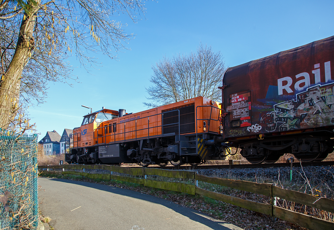 Die KSW 42 (92 80 1277 902-3 D-KSW), eine Vossloh MaK G 1700 BB, drückt am 03.03.2023, weitere leere Güterwagen vom Rangierbahnhof der KSW in Herdorf (Freien Grunder Eisenbahn KSW NE447 / DB-Nr. 9275), in den Bahnhof Herdorf. Im Bahnhof steht bereit die KSW 46 (277 807-4) mit dem ersten Teil von dem Übergabe-Güterzug. Beide Zugteile werden dort dann aneinander gekuppelt und im Sandwich (Vorne die KSW 42 und am Zugschluss die KSW 46), fahren sie dann nach Dillenburg. 

Eigentlich würde sie einfach via Betzdorf nach Kreuztal fahren, aber der Abschnitt Herdorf – Betzdorf bleibt, nach dem Felssturz am 23.12.2022 in Herdorf, bis voraussichtlich zum kleinen Fahrplanwechsel am 09. Juni 2023 gesperrt.