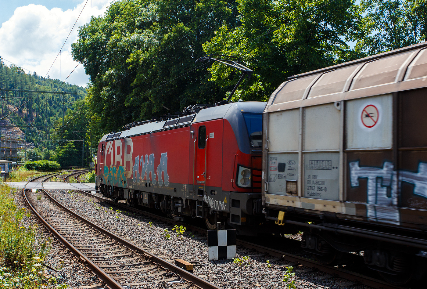 Die leider beschmierte ÖBB 1293 072 (91 81 1293 072-5 A-ÖBB), eine Siemens Vectron MS (X4E) in der Variante A35-1a (Länderpaket) der ÖBB-Produktion GmbH, fährt am 17 Juli 2025 mit einem sehr langen gemischten Güterzug durch den Bahnhof Kirchen (Sieg) in Richtung Köln.

Die SIEMENS Vectron MS / X4E wurde 2020 von Siemens in München-Allach unter der Fabriknummer 22759 und an die ÖBB - Österreichische Bundesbahnen (ÖBB-Produktion GmbH) geliefert. Sie ist in der Variante A35-1a ausgeführt und hat so die Zulassungen für A, D, I, SLO, CZ, SK, H, PL und HR. Von der Variante A35 hat die ÖBB insgesamt 123 Loks (1293 001-123).

Ende Januar 2017 unterzeichneten die Österreichischen Bundesbahnen und Siemens Mobility einen Rahmenvertrag über bis zu 200 Lokomotiven, wovon die ersten 30 Mehrsystem-Vectron direkt zum Gesamtpreis von 120 Mio. Euro abgerufen wurden.

Die Siemens Vectron weisen im Betrieb mit Wechselspannung eine Leistung von 6.400 kW, mit Gleichspannung 6.000 kW, auf und haben eine Masse von bis zu 90 Tonnen, die auf vier Achsen verteilt eine Achslast von 22,5 Tonnen ergibt. Aufgrund der überwiegenden Verwendung im Güterverkehr sind die Lokomotiven zunächst für 160 km/h zugelassen. Zur Verbesserung der Laufeigenschaften auf kurvenreichen Strecken wurden die Lokomotiven mit aktiven Drehdämpfern ausgerüstet

TECHNISCHE DATEN:
Spurweite: 1.435 mm (Normalspur)
Achsformel: Bo’Bo’
Länge über Puffer: 18.980 mm
Breite (über Handstangen): 3.012 mm
Höhe (Panto abgesenkt): 4.248 mm
Begrenzungslinie: UIC 505-1
Drehzapfenabstand:  9.500 mm
Achsabstand in Drehgestell:  3.000 mm
Raddurchmesser:  1.250 mm (neu) / 1.160 mm (abgenutzt)
Dienstgewicht: 90 t
Max. Radsatzlast: 22,5 t
Meterlast: 4.742 kg
Höchstgeschwindigkeit: 160 km/h  (Lok 1293.047-051 200 km/h)
Antriebsleistung: 6.400 kW (AC) / 6.000 kW (DC)
Anfahrzugkraft: 340 kN
Kleinster bef. Halbmesser: 80 m
Stromsysteme: 15kV/16,7Hz; 25kV/50Hz; 3kV DC (1,5kV DC)
Antriebsart: IGBT Stromrichter und Drehstrom Fahrmotore mit
Antrieb: Ritzelhohlwellenantrieb
Bremsbauart: KE-GPR-E m Z, (D), ep. Dynamisches Bremssystem Elektrodynamische Hochleistungs-Rückspeisebremse, für DC Netze zusätzlich Widerstandsbremse
Leistung der dynamischen Bremse: 6.400 kW (AC) / 6.000 kW (DC), Leistung der Widerstandsbremse: 2.600 kW (DC)
E-Bremskraft der dynamischen Bremse: 150 / 240 kN
Federspeicherbremse 45 / 50: 60 kN
Zugheizung: 900 kVA
Betriebliche Daten:
Zugbeeinflussungssysteme: Alstom IVC ETCS L1-2 + SCMT; LZB 80/E, PZB 90; MIREL VZ1; SHP
Sicherheitsfahrschaltung: Zeit-Zeit Impuls-SiFa
Zugfunk: GSM-R Dual Mesa 23 SW 4.9.3, Analogbetrieb 450 MHz gemäß UIC 751-3, GSM-R gemäß EIRENE FRS 7, SRS 15
Fern- und Vielfachsteuerung: UIC-WTB nach ÖBB Fernsteuerkonzept, ZMS-ZDS-ZWS

Quellen: ÖBB-Produktion GmbH, Siemens und wikipedia
