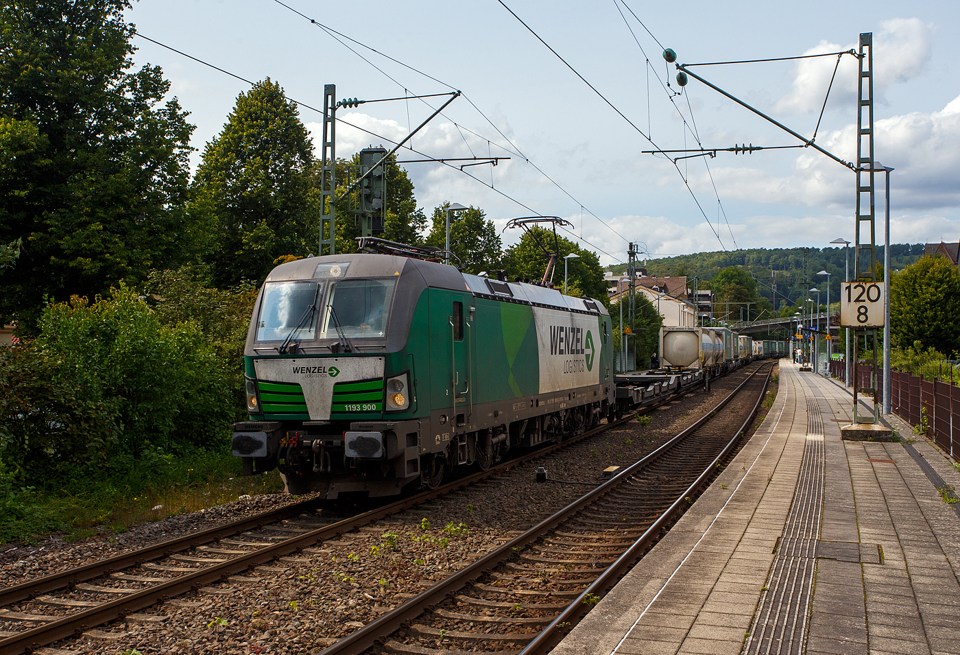Die österreichische Weco Rail / Wenzel Logistics SIEMENS Vectron AC 1193 900 (91 81 1193 900-8 A-WENA) der Weco Rail GmbH, Wien (ex Walser Eisenbahn GmbH) fährt am 05 August 2025, mit einem KLV-Ganzzug der österreichischen Wenzel Logistics GmbH (Werndorf), durch den Bahnhof Kirchen/Sieg in Richtung Köln.

Die SIEMENS Vectron AC wurde 2022 Siemens in München-Allach unter der Fabriknummer 23014 gebaut und an die damalige WEG - Walser Eisenbahn GmbH geliefert. Im April 2023 wurde die Walser Eisenbahn GmbH in Weco Rail GmbH umfirmiert. Zudem gab man die Partnerschaft mit der Wenzel Logistics GmbH bekannt, die mit zwei eigenen Siemens Vectron Lokomotiven agiert.

Diese Vectron Lokomotive ist als AC – Lokomotive (Wechselstrom-Variante) mit 6.400 kW Leistung und für eine Höchstgeschwindigkeit von 200 km/h konzipiert. Sie wurde in der Vectron Variante AC B14 ausgeführt und hat so die Zulassungen für Deutschland, Österreich, Ungarn, Tschechien, Slowakei, Rumänien und Bulgarien (D / A / H / CZ / SK / RO / BG). So besitzt die Variante AC B14 folgende Zugsicherungssysteme:
ETCS BaseLine 3, sowie für 
Deutschland (PZB90 / LZB80 (CIR-ELKE I))
Österreich (ETCS Level 1 mit Euroloop, ETCS Level 2, PZB90 / LZB80)
Ungarn (ETCS Level 1, EVM (Mirel))
Tschechien und Slowakei (LS (Mirel))
Rumänien und Bulgarien (PZB90)

TECHNISCHE DATEN:
Spurweite: 1.435 mm (Normalspur)
Achsformel: Bo’Bo’
Länge über Puffer: 18.980 mm
Breite (über Handstangen): 3.012 mm
Höhe (Panto abgesenkt): 4.248 mm
Begrenzungslinie: UIC 505-1
Drehzapfenabstand:  9.500 mm
Achsabstand in Drehgestell:  3.000 mm
Raddurchmesser:  1.250 mm (neu) / 1.160 mm (abgenutzt)
Dienstgewicht: 87 t
Max. Radsatzlast: 21,8 t
Meterlast: 4.742 kg
Höchstgeschwindigkeit: 200 km/h 
Antriebsleistung: 6.400 kW (AC)
Anfahrzugkraft: 340 kN
Kleinster bef. Halbmesser: 140 m (Strecke) / 80 m (Depot)
Stromsysteme: 15kV/16,7Hz und 25kV/50Hz
Antriebsart: IGBT Stromrichter und Drehstrom Fahrmotore mit Ritzelhohlwellenantrieb
Bremsbauart: KE-GPR-E m Z, (D), ep. Dynamisches Bremssystem Elektrodynamische Hochleistungs-Rückspeisebremse
Leistung der dynamischen Bremse: 6.400 kW 
E-Bremskraft der dynamischen Bremse: 150 / 240 kN
