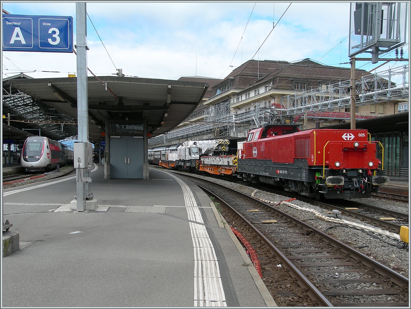 Die SBB Aem 940 025 (Aem 91 85 4 940 025-0 CH-SBB I) wartet mit dem mächtigen Rhomberg Sersa KRC 1200 Kranwagen (CH RSRM99 85 9219 102-2) und zwei Begleitwagen (33 85 4505 172-8 TEN-CH WASCO Sgmmns und 33 85 4505 173-6 TEN CH-WASCO Sgmmns) in Lausanne auf die Weiterfahrt.
Links im Bild ist noch ein TGV (Lyria) zu erkennen. 

24. April 2025