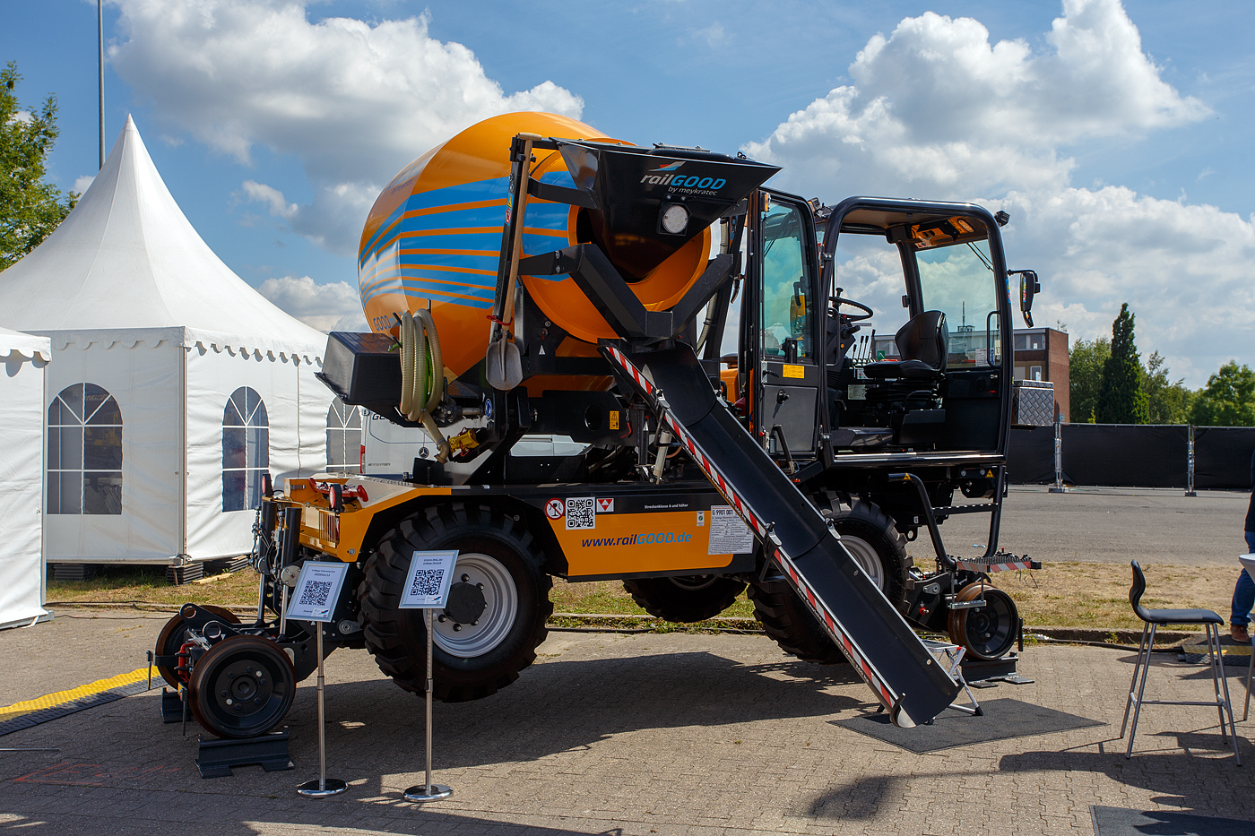 Die Weltneuheit im Gleisbau, der erste 2-Wege-Betonfahrmischer
Die railGOOD by Meykratec aus Bad Rothenfelde pr�sentierte auf der 29. Internationale Ausstellung Fahrwegtechnik 2025 (iaf) in M�nster (hier am 20 Mai 2025) den GOODmix 3,5, einen Betonmischer mit Schienenfahrwerk. Eine Innovation auf die die Welt des Gleisbaus gewartet hat. Zugelassen ist er als Gleisfahrende Baumaschine G 9901 001 (Art: Zweiwege-Betonmischer GOODmix 3,5). Ich finde ein sehr gelungenes Ger�t. 

Das Schienenfahrwerk des GOODmix 3,5 erm�glicht es dem Betonmischer sich m�helos auf den Gleisen zu bewegen, ohne dabei aufw�ndige Transportl�sungen oder zus�tzliche Maschinen zu ben�tigen. Dies spart nicht nur Zeit und Kosten, sondern erh�ht auch die Flexibilit�t und Produktivit�t auf der Baustelle. 

Dank seiner robusten Bauweise und leistungsstarken Mischtrommel liefert der GOODmix 3,5 zuverl�ssig eine gleichm��ige und hochwertige Betonmischung, die den Anforderungen des Gleisbaus in jeder Hinsicht gerecht wird. 

Das Basisfahrzeug ist ein DIECI Fahrmischer vom Typ AB L 4700 T des italienischen Herstellers Dieci s.r.l. aus Montecchio Emilia. Das Schienenfahrwerk ist vom niederl�ndischen Hersteller AMT aus Breda. Idee Entwicklung sind von railGOOD by Meykratec aus Bad Rothenfelde, die auch den Alleinvertrieb hat. 

Das Fahrzeug:
Der hydrostatische Antrieb mit Verstellpumpe, gew�hrleistet fl�ssige und genaue Bewegungen. Der unabh�ngige Hydraulikkreis f�r die Trommeldrehung garantiert maximale Mischleistungen. Die Mischtrommel verf�gt zur einfacheren Entleerung �ber eine Hubeinrichtung, sowie ein 180�-Drehsystem f�r eine dreiseitige Entleerung. Die Fahrerkabine, die sich hinsichtlich Ergonomie, Komfort und Sicherheitsausstattungen im gehobenen Segment ansiedelt, ist mit einem umkehrbaren Fahrerstand ausgestattet, so kann der Fahrer immer in Fahrtrichtung sitzen.

Technische Merkmale:
Abmessungen in Transportstellung 5.825 x 2.400 x 3.140 mm
Eigengewicht: ca. 9.500 kg
Max. Nutzlast: 5.000 kg
Inhalt Wassertank: 630 l

Dieselmotor: Wassergek�hlter 4 Zylinder Perkins-Dieselmotor mit Turbolader und Ladeluftk�hlung, sowie Direkteinspritzung, vom Typ 904J-E36TA (Stage V)
Motorleistung: 85,6 kW (116 PS) bei 2.200 U/min
Maximales Drehmoment: 566 Nm – 1.500 U/min
Motorhubraum: 3,621 l (Bohrung � 98 mm x 120 mm Hub)
H�chstgeschwindigkeit Offroad: 27 km/h 

Auf der Schiene:
Inbetriebnahme: 07.01.2025
Spurweite: 1.435 mm (Normalspur)
H�chstgeschwindigkeit: 19,5 km/h (in Arbeitsstellung 5 km/h)
Zur Mitfahrt zugelassene Personen: 1 (Fahrer + 1 Rangierbegleiter)
Zugelassene Streckenklasse: A und h�her
Laufraddurchmesser: 500 mm (neu)
Hydraulische Bremse auf allen vier Eisenbahnr�der im Laufwerk
Federspeicherbremsen auf allen vier Eisenbahnr�der im Laufwerk Durchmesser Schienenrad 500 mm
Max. Rampenwinkel 13,5�
Max. �berh�hung 200 mm
Fahrgeschwindigkeit Gleis Stufe 1 bis 9, Stufe 1 bis 2 9-19,5 km/h
Fahrgeschwindigkeit Offroad 27 km/h
