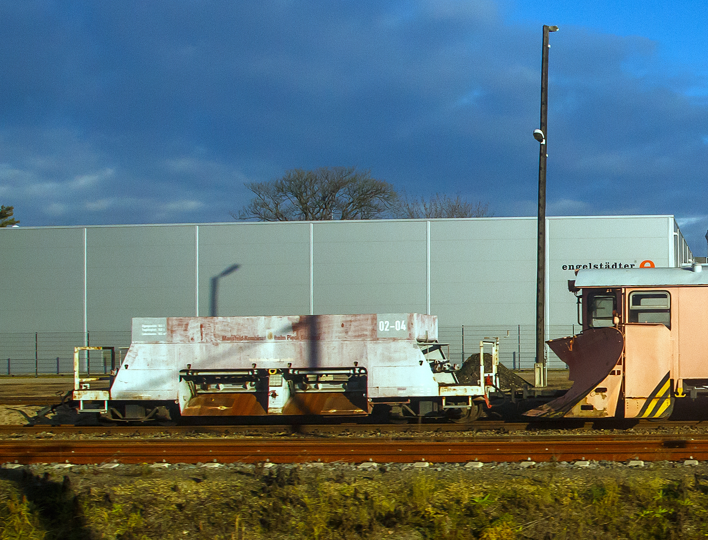 Ehemaliger vierachsiger Schmalspur (750 mm) Rohsteinwagen 02-04 der VEB Mansfeld Kombinat Wilhelm Pieck Eisleben (heute MBB - Mansfelder Bergwerksbahn), nun wohl als 4-achsiger Seitenentlade-Schotterwagen der Lnitzgrundbahn (zur SDG - Schsische Dampfeisenbahngesellschaft mbH), angestellt am 08.12.2022 in Radebeul Ost, aufgenommen aus einem IC).

Seit dem Ende des Kupferbergbaus werden diese Wagen nur noch in historischen Gterzgen zum Transport von Rohsteinen verwendet. Da sie sich aber gut fr den Transport von Schotter eignen und ihn zugleich auch an die richtigen Stellen platzieren knnen, sind sie oft fr die Unterhaltung der Strecken im Einsatz. Deswegen machen auch andere Bahnen (wie hier die SDG) gern von diesem Wagentyp Gebrauch.

Diese Wagen wurden 1953 vom VEB Waggonbau Gotha, die zur Vereinigung Volkseigener Betriebe Lokomotiv- und Waggonbau (VVB LOWA) gehrte, fr die Mansfelder Bergwerksbahn gebaut.

TECHNISCHE DATEN:
Bezeichnung : Schttgutwagen / Bauart Sattelboden-Selbstentlader
Spurweite: 750 mm
Anzahl der Achsen: 4 (in 2 Drehgestellen)
Lnge ber Kupplung: 9.400 mm
Drehzapfenabstand: 6.300 mm 
Breite: 2.000 mm 
Auswurfbreite:1.600 mm (800 mm von Greismitte)
Achsanstand im Drehgestell: 1.320 mm
Laufraddurchmesser: 600 mm (neu) 
Eigengewicht: 10.500 kg
Max. Ladegewicht: 20.000 kg
Max. Achslast: 7,5 t
Ladevolumen: 10,0 m
Lnge der Beladeffnung: 8.000 mm
Kleinster befahrbarer Gleisbogen: R = 60 m
Bremse: Druckluftbremse Knorr / Handbremse
