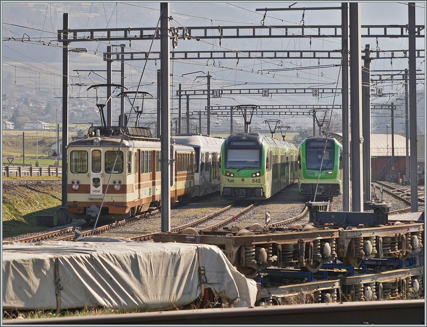 Ein Blick über die SBB Gleise ins TPC Dépôt En Châlet bei Aigle trotz ein wenig störenden Fahrleitungselemente: Rechts steht der AL BDeh 4/4 302, auf dem gleichen Gleis die zweie AVA (ex AAR) Abt, daneben der TPC Beh 2/6 545 und abschliessend ein neuer ABe 4/8. 

4. Feb. 2024