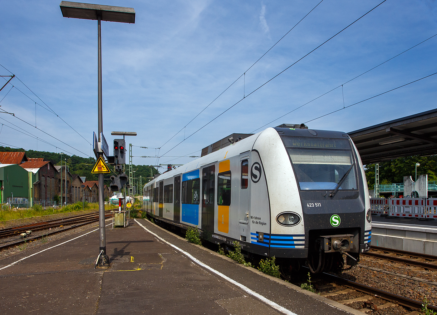 Ein ET 423 der S-Bahn Stuttgart im neuen Redesign auf Abwegen….
Der vierteilige Elektrotriebzug 94 80 0423 511-5 D-DB / 433 511-3 / 433 011-4 / 423 011-6 ein „Kurzzug“ der Baureihe 423 (1. Bauserie) der S-Bahn Stuttgart fährt am 18. Juni 2025, auf Werkstattfahrt, durch den Bahnhof Betzdorf/Sieg in Richtung Siegen. Vermutlich ging es wieder zurück nach Stuttgart.

Die Triebzüge der Baureihe 423/433 sind S-Bahn-Triebzüge, die seit 1998 den Vorgänger DB-Baureihe 420 ablösen. Die Fahrzeuge wurden ursprünglich für die S-Bahn München konzipiert, kommen aber auch bei der S-Bahn Köln, der S-Bahn Stuttgart und der S-Bahn Rhein-Main zum Einsatz. Mit Baureihe 423 werden die beiden angetriebenen Endwagen bezeichnet, während die ebenfalls angetriebenen Mittelwagen in die Baureihe 433 eingeordnet werden. Gebaut wurden die Triebzüge von einem Konsortium bestehend aus Adtranz, Alstom LHB, ABB und Bombardier. Dieser Triebzug wurde 1999 von Alstom LHB in Salzgitter-Watenstedt unter den Fabriknummern 423.0-017, 433.0-017, 433.5-017 und 423.5-017 gebaut.

Die Baureihe wurde in fünf Bauserien gebaut und geliefert:
    1. Bauserie: 423 001 – 423 190
    2. Bauserie: 423 191 – 423 300
    3. Bauserie: 423 301 – 423 371
    4. Bauserie: 423 372 – 423 396
    5. Bauserie: 423 397 – 423 462

Die vierteiligen Triebzüge der Baureihe 423 sind 67,40 Meter lang, sie laufen auf zwei Endtriebdrehgestellen und drei Jakobs-Drehgestellen (2 als Trieb- und in der Mitte ein al Laufdrehgestell. Der Triebzug ist für den S-Bahn-Betrieb konzipiert und besitzt daher kein WC. Als Leichtbaufahrzeug besteht er größtenteils aus Aluminium. Als Antrieb wird hier Drehstromtechnik mit Bremsstromrückspeisung eingesetzt, die Leistung beträgt 2.350 Kilowatt. Die zulässige Höchstgeschwindigkeit des Triebzugs beträgt 140 km/h.

Ein „Kurzzug“ der Baureihe 423 besteht dabei aus vier Wagen:
Endtriebwagen (ETW) 1: 423 001 – 462
Mitteltriebwagen (MTW) 2: 433 001 – 462
Mitteltriebwagen (MTW) 3: 433 501 – 962
Endtriebwagen (ETW) 4: 423 501 – 962

Die Ordnungsnummern der einzelnen Wagen beruhen dabei im Lieferzustand stets auf dem gleichen Schema, die vorderen beiden Wagen haben die gleiche Ordnungsnummer, während die hinteren beiden Wagen die um 500 erhöhte Ordnungsnummer tragen.

Zwei Kurzzüge bilden einen „Vollzug“, drei Kurzzüge bilden einen „Langzug“.

Die Triebzüge werden von acht vierpoligen, wassergekühlten Drehstrom-Asynchron-Fahrmotoren mit einer Gesamtleistung von 2.350 Kilowatt angetrieben. Die beiden Traktionsanlagen der Züge, die über einen gemeinsamen Stromabnehmer mit Energie versorgt werden, sind weitgehend voneinander unabhängig.

Die Züge verfügen über eine Notbremsüberbrückung. Betriebsbremsungen erfolgen über elektrodynamische Bremsen. Von den 16 Bremszylindern der elektropneumatischen Bremse sind sechs mit einem Federspeicher ausgerüstet.

Das mittlere der fünf Drehgestelle ist aus Laufdrehgestell ausgeführt (antriebslos) dieses hat auch keine Bremsen. 

TECHNISCHE DATEN:
Gebaute Einheiten: 462
Spurweite: 1.435 mm (Normalspur)
Achsformel: Bo’(Bo’) (2’) (Bo’) Bo’ (in Klammern Jakobs-Drehgestellen)
Länge über Kupplung: 67.400 mm 
Drehzapfenabstände: 15.140 mm (Endwagen) / 15.460 mm (Mittelwagen)
Achsabstand im End-Drehgestell: 	2.200 mm 
Achsabstand im Jakobs-Drehgestell: 2.700 mm
Treib- und Laufraddurchmesser: 850 mm (neu) / 780 mm (abgenutzt)
Leergewicht: 105,1 t
Höchstgeschwindigkeit: 140 km/h 
Leistung: 8 x 293,75 = 2.350 kW
Beschleunigung: 1,0 m/s²
Bremsverzögerung: 0,9 m/s²
Motorentyp: Drehstrom-Asynchron  vom Typ 	4 WIA 3558 G
Anzahl der Fahrmotoren: 8
Kupplungstyp: Scharfenbergkupplung Typ 10
Sitzplätze: 192
Fußbodenhöhe: 1.025 mm (Einstiegshöhe von 995 mm)
