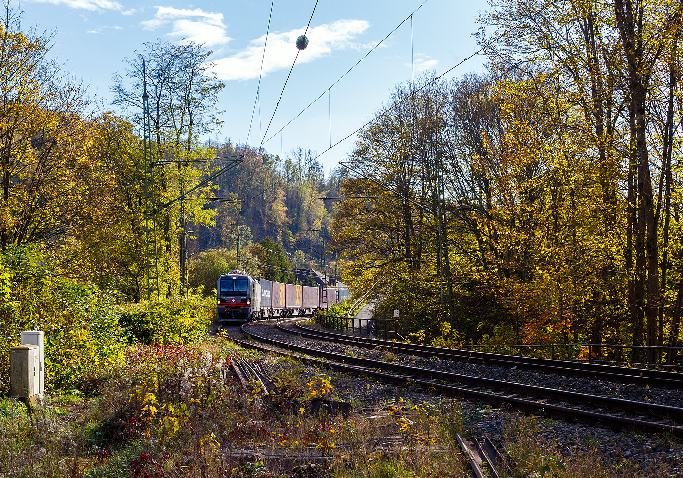 Ein fast fabrikneuer SIEMENS XLoad-Vectron, gerade mal 4 Wochen alt.
Die an die SBB Cargo International AG vermietete 193 549 mit XLoad  Duomo Milano  (91 80 6193 549-3 D-SIEAG) der SüdLeasing GmbH, Stuttgart (eingestellt in Deutschland durch Siemens) fährt am 29.10.2024 mit einem KLV-Zug, durch Kirchen (Sieg) in Richtung Siegen.

Die Multisystemlokomotive Siemens Vectron MS wurde 2024 von Siemens Mobilitiy in München-Allach unter der Fabriknummer 23595 gebaut und am 25.09.2024 ausgeliefert. Sie wurde in der Variante A40-1a ausgeführt und hat so die Zulassung für Deutschland, Österreich, die Schweiz, Italien, die Niederlande und Belgien (D / A / CH / I / NL / B). Sie verfügt über eine Leistung von 6,4 MW (160 km/h) und ist neben den nationalen Zugsicherungssystemen mit dem Europäischen Zugsicherungssystem (ETCS  BL3) ausgestattet. Zudem ist sie mit der neuen Ausrüstungspaket XLoad ausgestattet. 

Das neue XLoad Ausrüstungspaket für Vectron:
XLoad ist ein Ausrüstungspaket für Vectron, welches künftig mitbestellt, aber auch bei bereits ausgelieferten Vectron Loks nachgerüstet werden kann. Das Feature verbessert die Reibwertausnutzung und ermöglicht dadurch höhere Anhängelasten. Zudem reduzieren die Fahreigenschaften, die das Feature bewirken, den Verschleiß von Rad und Schiene.

Aktuell sind die Schweizer Vectron-Lokomotiven (SBB Cargo und BLS Cargo) in der Regel in Doppeltraktion unterwegs. Die Steigungen und Rampen der Schweizer Berge sind vor allem bei schlechten Witterungsbedingungen nicht ohne. Eine Lokomotive muss auch bei geringerem Schlupf genügend Traktion auf die Schienen bringen, um alle Güter sicher und zuverlässig ans Ziel zu bringen. Ein effizienter Weg aus dieser «Misere» ist die für Vectron entwickelte Zusatz-Funktion «XLoad». Den erfolgreichen Beweis trat eine SIEMENS Testlokomotive im Frühjahr 2022 bei der SBB Cargo International und bei der BLS Cargo eindrücklich an. 

Für SBB Cargo International bewies die Test-Lokomotive am Bözberg und für BLS Cargo an der Nordrampe des Lötschbergs ihre enorme Zugkraft. 
Vectron meisterte im Frühjahr 2022 die lange 12‰-Steigung des Bözbergs mit einer Anhängerlast von 2.000 Tonnen bravourös. Bei den nächtlichen Testfahrten zeigte sich eindrücklich die enorme Zugkraft der Lokomotive. 

Am Lötschberg wurden bei der BLS Cargo steigungsmäßig noch ein paar Promille draufgepackt. Mit 1.020 Tonnen im Gepäck bewältigte die Vectron-Lokomotive mit XLoad-Feature die 27‰-Steigung der Nordrampe ebenfalls meisterlich. Und auch diverse Anfahrtsversuche absolvierte der mit dem XLoad-Feature aufgerüstete Vectron problemlos. 

So bestellte die SüdLeasing GmbH (Stuttgart) im Auftrag der SBB Cargo International jüngst 20 Vectron Lokomotiven mit XLoad bei SIEMENS.
