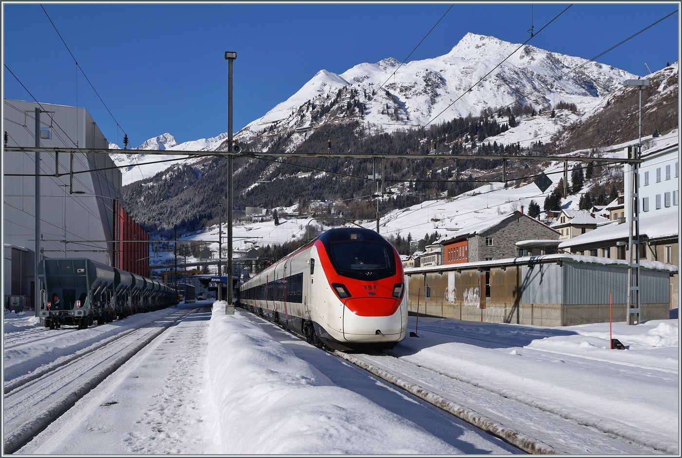 Ein SBB RABe 501  Giruno  rollt leise durch den verschneiten Bahnhof von Airolo in Richtung Süden. 

21. Jan. 2025