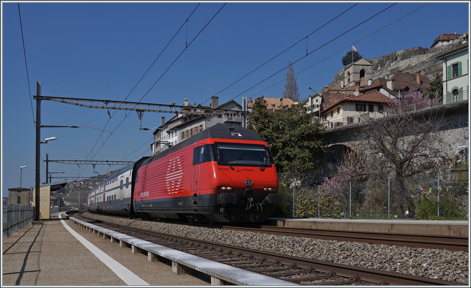 Eine SBB Re 460 ist mit ihrem IR 90 bei St-Saphorin auf dem Weg nach Brig.

25. März 2022