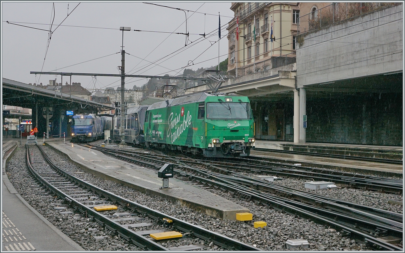 Eine weitere Bildvaariante mit der Ge 4/4 8004 etwas mehr im Vordergrund: Die beiden MOB Werbeloks Ge 4/4 8001 und 8004 mit ihren GoldenPass Express Zügen in Montreux. Die Ge 4/4 8004 ist mit dem GPX 4065 von Interlaken Ost angekommen und fährt nun zur Abstellung, während die Ge 4/4 8001 in wenigen Minuten mit ihrem GPX 4074 in Richtung Interlaken Ost abfahren wird. 7. Dez. 2024 