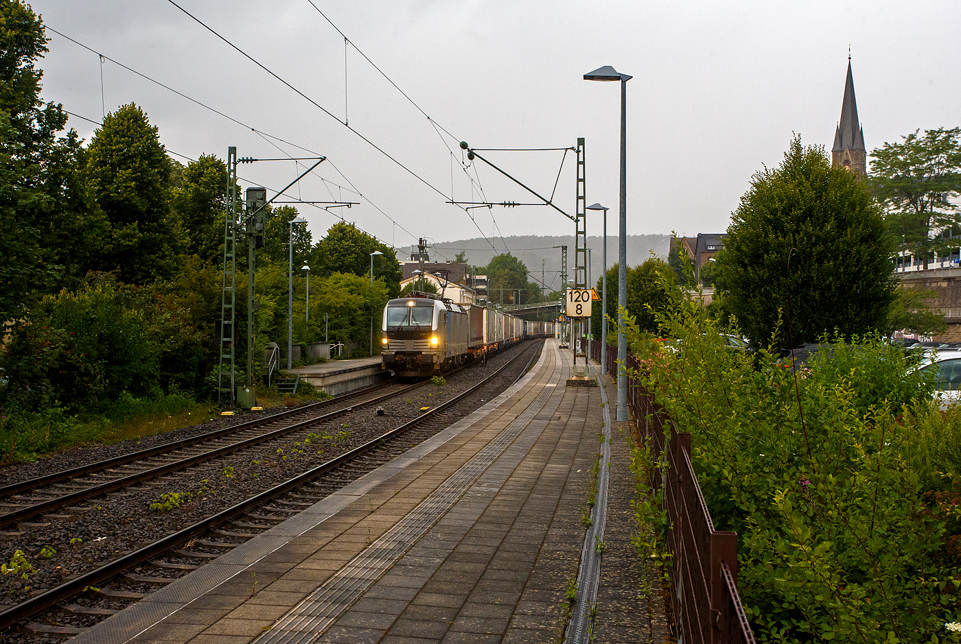 Es begann zu regnen und wir wollten schon den Heimweg antreten, da ging die Schranke am Bü herunter, das kann nur ein Güterzug sein, so ich ging wieder an den Bahnsteig. Die Siemens Vectron MS 6193 185 (91 80 6193 185-6 D-Rpool) der Railpool GmbH (München) fährt am 16 Juli 2025 mit einem KLV-Zug durch den Bahnhof Kirchen/Sieg in Richtung Köln. Nochmals einen lieben Gruß an den freundlichen Lokführer zurück.

Die Multisystemlokomotive Siemens Vectron MS wurde 2024 von SIEMENS Mobilitiy in München-Allach unter der Fabriknummer 23485 gebaut. Sie wurde in der Variante MS A54 ausgeführt und hat so die Zulassungen und Länderpakete für Deutschland, Österreich, Belgien, die Niederlande, Tschechien, die Slowakei, Ungarn, Rumänien und Polen. Für Serbien (SRB), Bulgarien (BG) und Kroatien (HR) sind auch Zulassungen vorgesehen, aber ist z.Z. noch durchgestrichen.

So besitzt die Variante MS A54 folgende Zugsicherungssysteme: ETCS BaseLine 3, sowie für Deutschland (PZB90 / LZB80 (CIR-ELKE I)), für Österreich (ETCS Level 1 mit Euroloop, ETCS Level 2, PZB90 / LZB80), für Belgien (ETCS L1, ETCS L2, TBL1+), für die Niederlande (ETCS Level 1, ETCS Level 2, ATB-EGvV), für Tschechien und die Slowakei (LS (Mirel)), für Ungarn (ETCS Level 1, EVM (Mirel)), für Polen (SHP) und für Rumänien, Serbien, Bulgarien und Kroatien (PZB90).