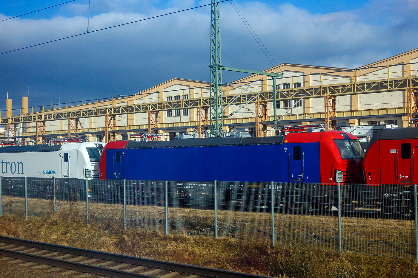 Frisch aus der Produktion, noch nicht ausgeliefert, die SIEMENS Vectron AC – 193 070-0 (91 80 6193 070-0 D-RCM) für die RCM Rail Care and Management GmbH (München), steht am 13 Januar 2025auf dem Werksgleisen vor den Werkshallen der SIEMENS Mobilitiy in München-Allach. Aufnahme aus einem ICE heraus.