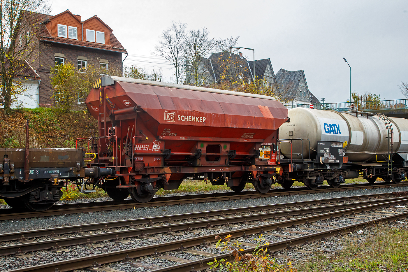 Gedeckter Schüttgutwagen mit dosierbarer Schwerkraftentladung und zwei Radsätzen 21 80 0734 600-8 D-DB, der Gattung Tds 937, der DB Cargo AG abgestellt, im Zugverband eines Übergabezuges der KSW, am 03.11.2022 in Herdorf auf dem Rbf. der KSW.

In diesen Wagen wird Ammoniumnitrat (Gefahrgutnummer 50/1942) zur Sprengstoff Herstellung zur Fa. Dynamit Nobel Defence nach Burbach-Würgendorf gefahren (hier ist er leer).  Ammoniumnitrat ist der Stoff  von dem ca. 2.750 Tonnen im Hafen von Beirut am 4. August 2020 explodierten und zur der bekannten gewaltigen Explosionskatastrophe führten.

Der Wagen trägt außerdem einen Aufkleber der Firma YARA Rostock, das zum norwegischen Konzern Yara International gehört. Yara ist ein Hersteller und Anbieter von Chemikalien und Industriegasen wie Dünger, Harnstoff, Nitraten und Ammoniak. Das Unternehmen entstand 2004 durch Abtrennung vom Unternehmen Hydro Agri, einem Firmenbereich von Norsk Hydro.

Die Wagen besitzen eine gleisseitige, dosierbare Entladeeinrichtung. Ein Innenanstrich erhöht bei den meisten der Fahrzeuge den Gebrauchswert, insbesondere durch den Schutz vor Verunreinigungen, Möglichkeiten des Transportes von Lebensmitteln, günstigeres Entladeverhalten (Rutschverhalten) bei schwer fließenden Gütern sowie durch verbesserten Korrosionsschutz bei aggressiven Ladegütern.

Der Wagen ist für den Transport von nässeempfindlichen Schüttgütern aller Art, wie z. B. Salze und Düngemittel, vorgesehen. Sie besitzen eine gleisseitige, dosierbare Entladeeinrichtung. Ein Innenanstrich erhöht bei den meisten der Fahrzeuge den Gebrauchswert, insbesondere durch den Schutz vor Verunreinigungen, Möglichkeiten des Transportes von Lebensmitteln, günstigeres Entladeverhalten (Rutschverhalten) bei schwer fließenden Gütern sowie durch verbesserten Korrosionsschutz bei aggressiven Ladegütern. Der Transport grobkörniger oder kantiger, schwerer Güter (z. B. Kies, Schlacke, Schotter) ist wegen einer möglichen Beschädigung der Innenbeschichtung nicht zulässig.

Das Untergestell und der Wagenkasten sind als Schweißkonstruktion unter Verwendung von Walzprofilen und Blechen hergestellt. Beide Teile sind miteinander verschweißt. Der Wagen besitzt zwei Bühnen, die von beiden Seiten zugänglich sind. Beide Bühnen sind mit einer Sprossenleiter versehen. Die Arbeitsbühne ist mit Handhebeln zur Betätigung der Wölbschieber, mit dem Handrad zur Öffnung des Daches und teilweise mit einer Feststellbremse und Notbremshahn ausgerüstet. Der Neigungsgrad des trichterförmigen Wagenkastens ermöglicht eine restlose selbsttätige Entladung. Die Entladung des Wagens erfolgt über Wölbschieber. Der Wagen ist mit einem einschaligen Hubschwenkdach ausgerüstet. Das Dach wird vor dem Schwenken angehoben und dann seitlich abgeschwenkt, wobei die gesamte Breite der Beladeöffnung freigegeben wird. Im geschlossenen Zustand ist das Dach gegen unbeabsichtigtes Verschwenken gesichert.

TECHNISCHE DATEN:
Spurweite: 1.435 mm
Achsanzahl: 2
Länge über Puffer: 9.640 mm
Achsabstand: 6.000 mm
Laufraddurchmesser: 1.000 mm (neu)
Wagenhöhe: 4.198mm
Größe der Beladeöffnung Länge x Breite: 8.000 x 1.200 mm
Laderaum: 38 m³
Eigengewicht: 12.700 kg
Höchstgeschwindigkeit: 100 km/h (beladen) / 120 km/h (leer)
Maximales Ladegewicht: 27,0 t  ab Streckenklasse C
Kleinster bef. Gleisbogenradius: 35 m
Bauart der Bremse: KE-GP (LL)
Bremssohle: IB 116
Intern. Verwendungsfähigkeit: RIV

Auch in dem Kesselwagen davor 33 80 7929 695-4 D-GATXD, der Gattung Zacns, wurde ein Rohstoff für die Herstellung von Sprengstoffen transportiert und zwar Salpetersäure.