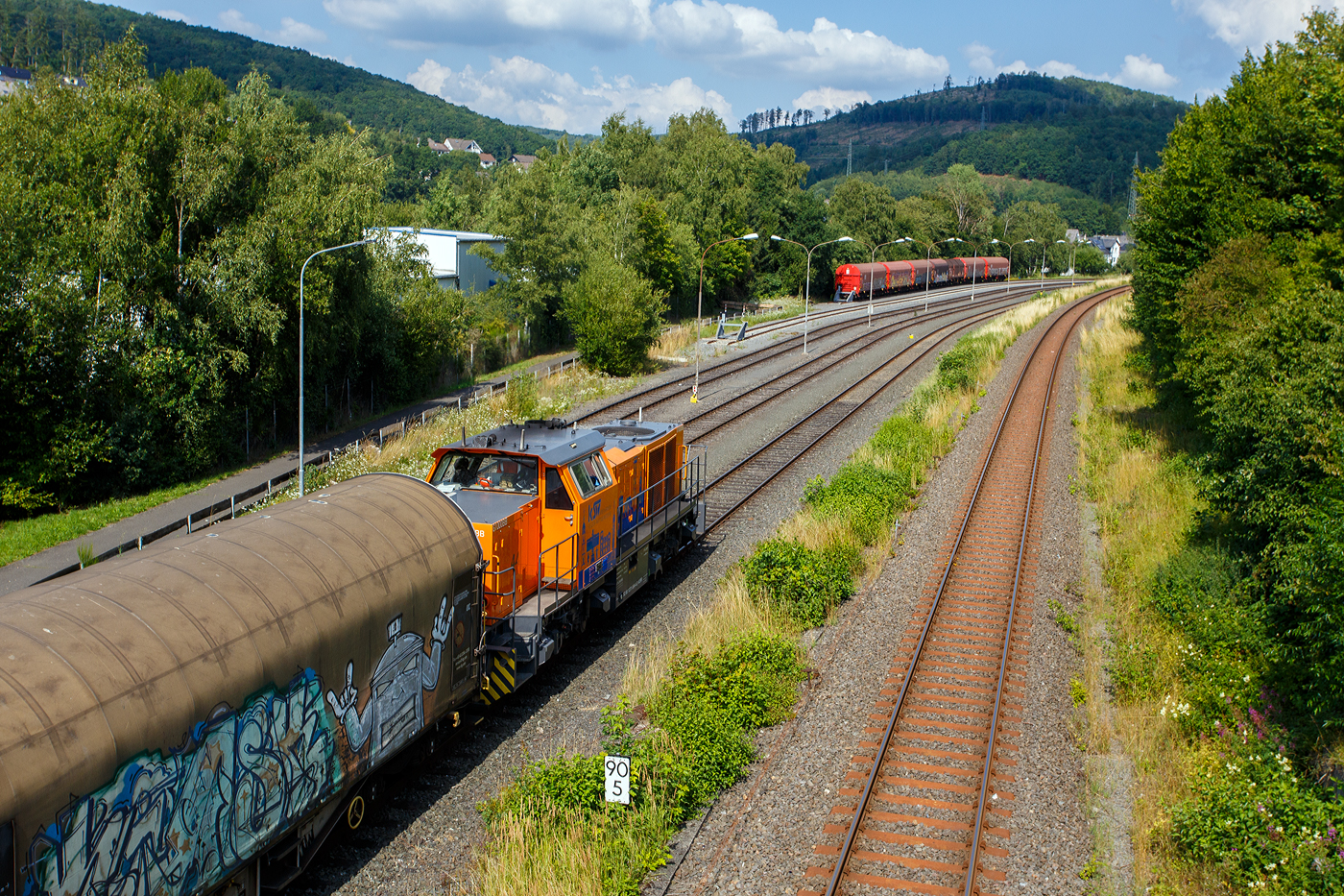 Geführt von der KSW 44 (92 80 1271 004-4 D-KSW) eine MaK G 1000 BB, fährt am 25 Juli 2025 die KSW (Kreisbahn Siegen-Wittgenstein), im Sandwich mit einem sehr langen und schweren Coilzug, auf den KSW-Rangierbahnhof (Betriebsstätte FGE - Freien Grunder Eisenbahn) in Herdorf. Hinten (nicht im Bild) ist nachschiebende an die KSW vermietete 272 408-6 / D20 der Bentheimer Eisenbahn AG (92 80 1272 408-6 D-BE), ex Rurtalbahn V 203 (92 80 1272 408-6 D-RTBC), eine Vossloh G 2000BB (mit symmetrischem Führerhaus).