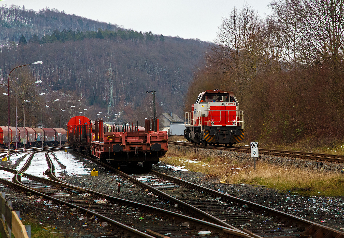 Güterverkehr gibt es noch in Herdorf....
Die KSW 47 (92 80 1271 027-5 D-KSW), ex D 2 der HFM, eine Vossloh G 1000 BB der KSW (Kreisbahn Siegen-Wittgenstein), fährt am 24.01.2023 von Herdorf auf der Hellertalbahn (KBS 462 / Strecke-Nr. 2651) in Richtung Haiger los.

Normalerweise würde sie in Richtung Betzdorf fahren, aber der Streckenanschnitt Herdorf – Betzdorf ist bis min. Ende April gesperrt, so muss die KSW den Umweg über Haiger fahren. Wobei hier als Lokzug ist es nur der Umweg und der entsprechende Mehrverbrauch an Kraftstoff, aber für den Güterverkehr ist noch die Streckenklasse sehr entscheidend und die beträgt bei dem Streckenanschnitt Herdorf – Haiger nur CE (anstatt D4 zwischen Betzdorf und Herdorf). Bei CE beträgt die Radsatzlast max. 20 t bei D4 aber 22,5 t. Dadurch kann ein Coil weniger geladen werden, da man nicht gerademal Coils vierteln kann, ergibt sich daraus ein bis zu 35% geringeres Ladegewicht und ein Mehraufwendung von Waggons.
