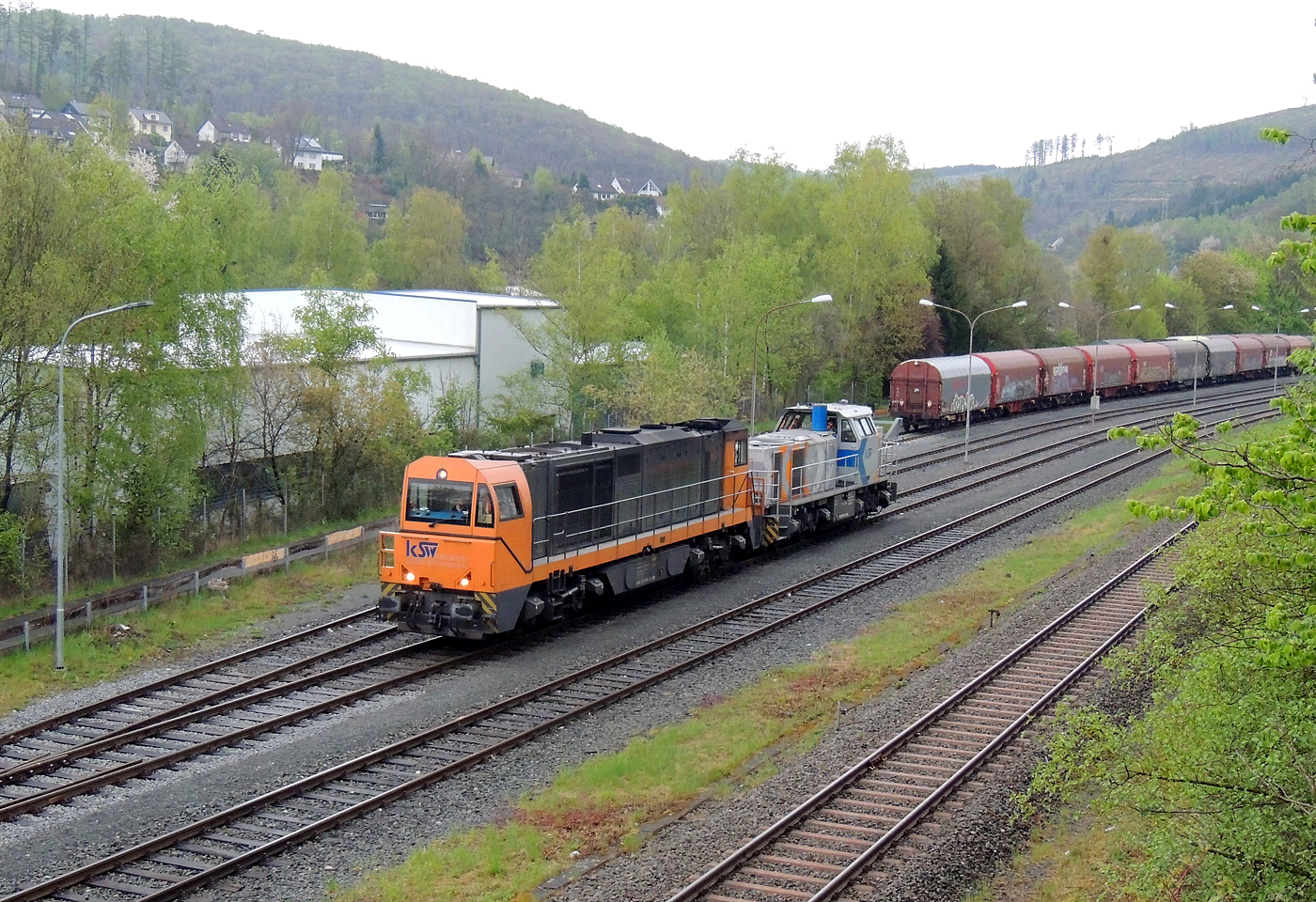 Hochbetrieb in Herdorf am 23 April 2025:
Nach getaner Arbeit fahren nun die beiden Loks der KSW (Kreisbahn Siegen-Wittgenstein) die KSW 43 (92 80 1273 018-2 D-KSW) die asymmetrische Vossloh G 2000 BB und die KSW 47 (92 80 1271 027-5 D-KSW), ex D 2 der HFM, eine Vossloh G 1000 BB, geneinsam als Lokzug vom KSW-Rangierbahnhof (Betriebsstätte FGE - Freien Grunder Eisenbahn) wieder zurück in Richtung Betzdorf/Sieg. 
