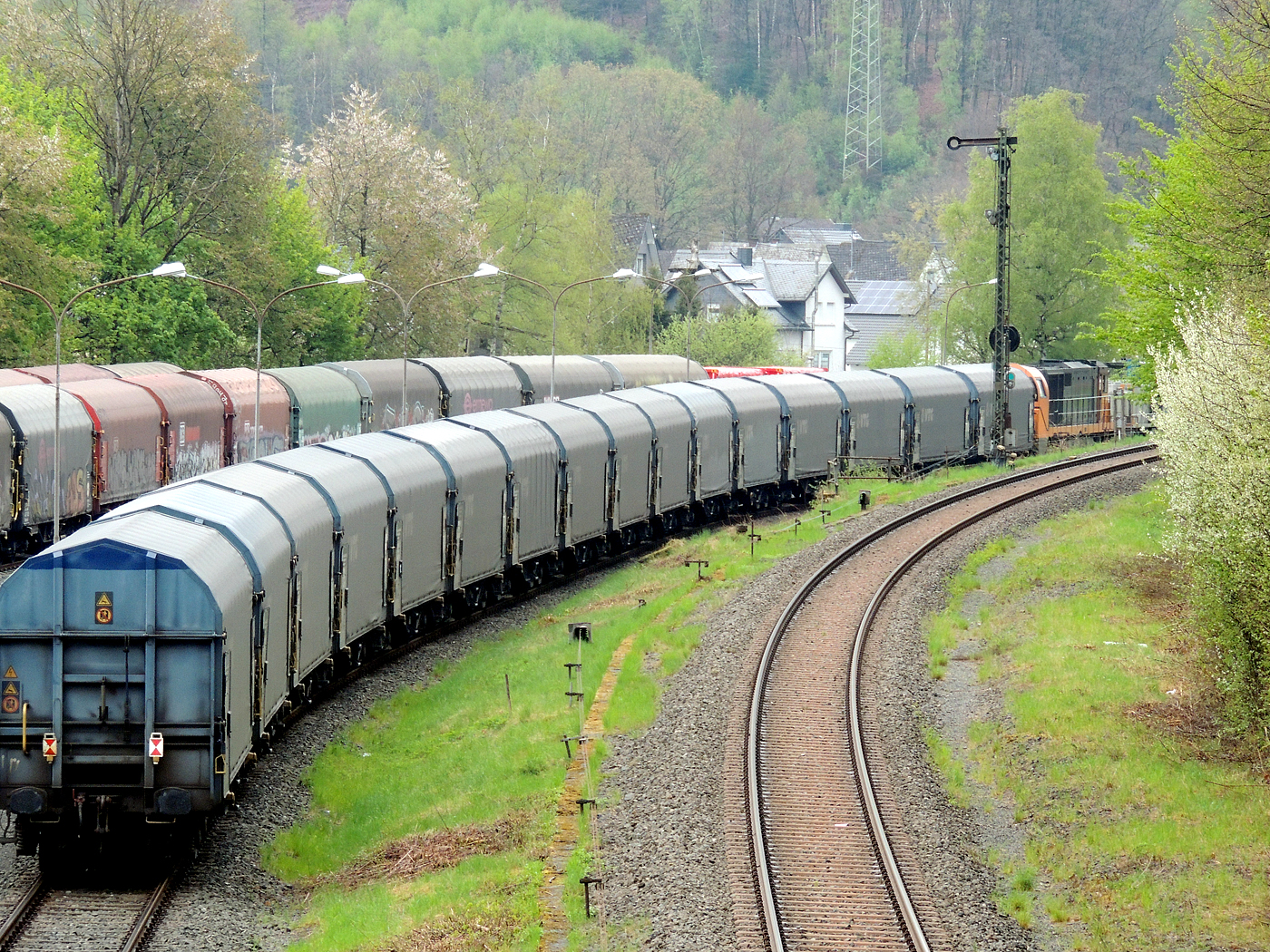 Hochbetrieb in Herdorf am 23 April 2025:
Zuvor hatten ja schon die KSW 44 und die nachschiebende KSW 47 mit sehr langen Coilzug den KSW-Rangierbahnhof in Herdorf (Betriebsstätte FGE - Freien Grunder Eisenbahn) erreicht.

Nun hat auch die die KSW 43 (92 80 1273 018-2 D-KSW), die asymmetrische Vossloh G 2000 BB, mit einem langen Coilzug (VTG Coilwagen der Gattung Shimmns-ttu, VTG Bez. F46.520D) vom Hafen Duisburg kommend den Rbf erreicht.

Den Zug übernimmt gleich die KSW 44, die diesen dann Teil weiter zu den Schäfer Werke KG am Pfannenberg in Neunkirchen-Salchendorf, da wegen den Achslasten dafür besser geeignet ist. Die KSW 43 und die KSW 47 fahren später gemeinsam als Lokzug zurück in Richtung Betzdorf/Sieg. 