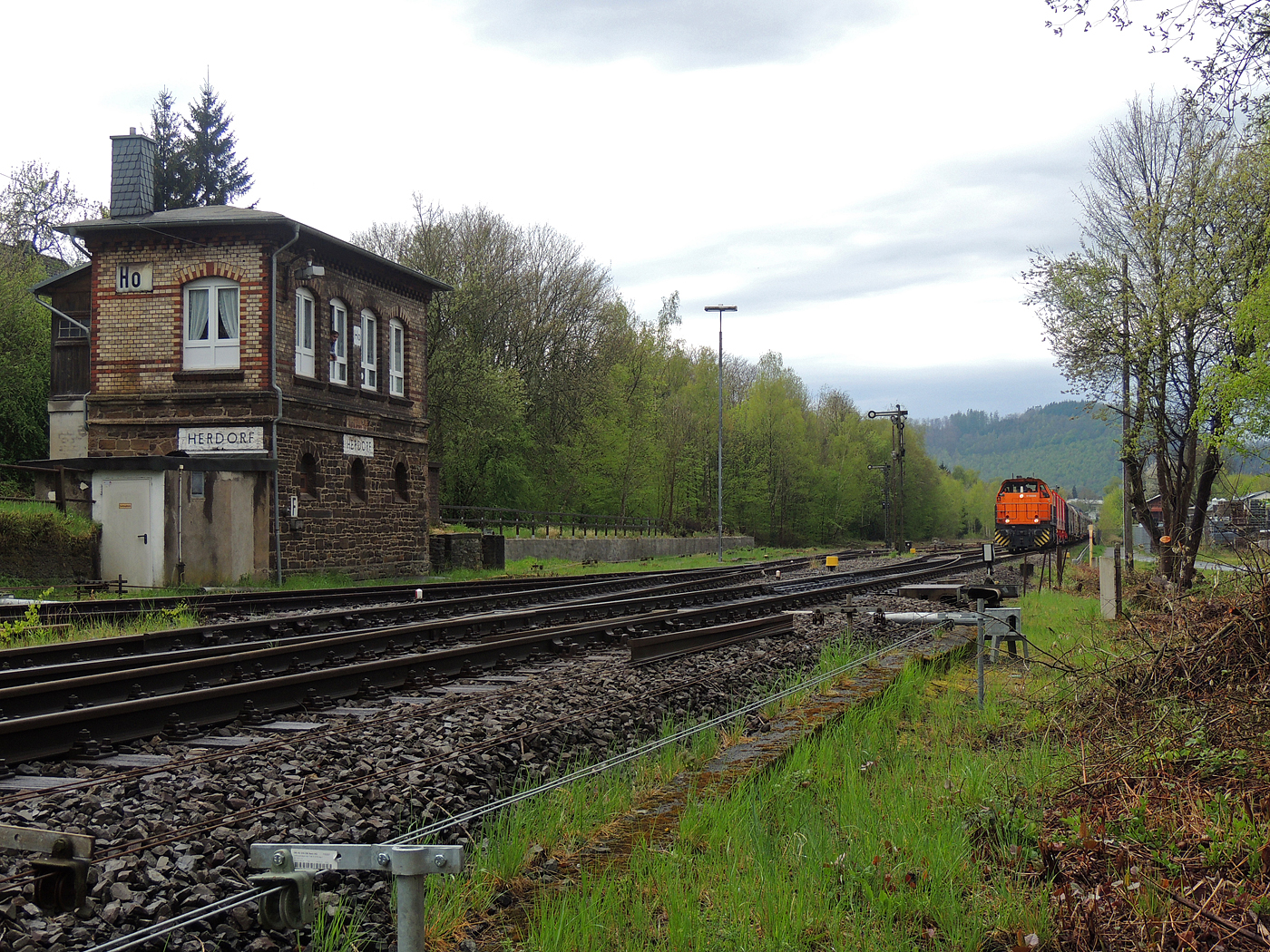 Hochbetrieb in Herdorf am 23 April 2025: 
Durch die vergangenen Osterfeiertage braucht es wohl wieder Nachschub. Die KSW (Kreisbahn Siegen-Wittgenstein) kommt im Sandwich mit einem sehr langen und somit schweren Coilzug, von via Betzdorf/Sieg kommend in Herdorf an. Gleich drauf geht es auf den KSW-Rangierbahnhof (Betriebsstätte FGE - Freien Grunder Eisenbahn). Übrigens die neuen m²-Güterwagen/Tragwagen der Gattung Uas 224.2 für Coiltransporte der DB Cargo AG sind hier immer mehr anzutreffen.

Vorne als Zuglok die KSW 44 (92 80 1271 004-4 D-KSW) eine MaK G 1000 BB und hinten nachschiebend die KSW 47 (92 80 1271 027-5 D-KSW), ex D 2 der HFM, eine Vossloh G 1000 BB.

Im Rbf wird der Zug geteilt, da er für die Weiterfahrt sonst zu lang wäre, und die KSW 44 zieht den ersten Teil weiter zu den Schäfer Werke KG am Pfannenberg in Neunkirchen-Salchendorf. 

Später kam dann noch die KSW 43 (92 80 1273 018-2 D-KSW), die asymmetrische Vossloh G 2000 BB, mit einem langen Coilzug von Duisburg an.