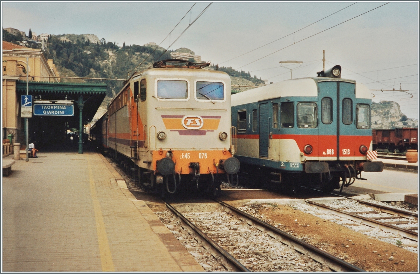 Im Bahnhof von Taormina-Giardini steht die FS E. 646 078 mit einem Regionalzug in Richtung Catania und auf Gleis zwei der FS Aln 668 1513. 

Analogbild vom April 1994