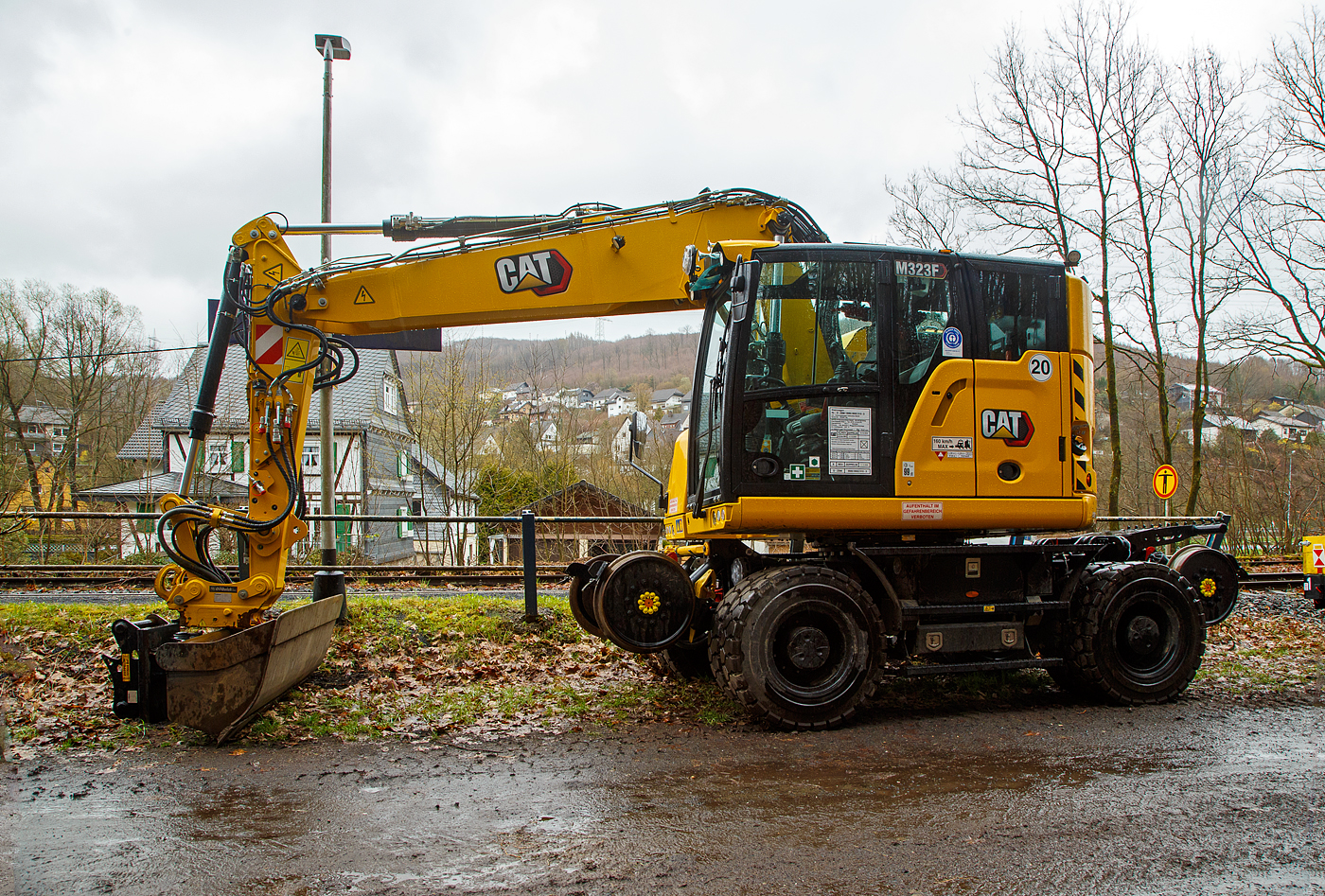 Neuer Zweiwegebagger....
Der Caterpillar CAT M323F Zweiwegebagger mit hydrostatischem Schienenradantrieb (Serien-Nr. RH600 160), Kleinwagen Nr. D-ZBM 99 80 9902 510-3 der ZEPPELIN Baumaschinen GmbH (Garching) ist am 01.04.2023 beim Hp Grnebach Ort (an der Hellertalbahn) abgestellt. 

Der Zweiwegebagger wurde im Juni 2022 unter der Fabrik-Nr. CAT M323FERH600160 gebaut.

Schienenradantrieb
Der CAT Zweiwegebagger mit hydrostatischem Schienenradantrieb (vom franzsischen Spezialmaschinenbauer UNAC) ist konsequent fr den Einsatz auf der Schiene entwickelt. Mit seinem kurzen Heck, dem innovativen Radantrieb und Bremssystem fr alle Gleisrder und dem ausgefeilten, aber einfach bedienbaren Kontrollsystem erschliet der Cat M323F den Anwendern entscheidende Vorteile.Anders als bei den bisher blichen Zweiwegebaggern bewegt sich die Maschine auf der Schiene damit nicht abgesenkt auf den herkmmlichen Rdern voran, sondern ohne Bodenkontakt auf den Schienenrdern selbst. Die hohe Bodenfreiheit gewhrleistet dabei, dass die Sicherheitseinrichtungen im Gleisbett beim Fahren nicht beschdigt werden. Mit dem Bremssystem im lbad an beiden Achsen und den Scheibenbremsen fr alle Gleisrder gewhrleistet der Cat M323F sicheren Vortrieb und kraftvolle Beschleunigung bis auf 20 km/h.

Klassische Zweiwegebagger sind vielfach noch mit Reibradantrieb ausgestattet. Die Reifen des Baggers werden dabei auf die Schienen oder Rolle gepresst und bertragen so die Antriebs- und Bremskrfte. Die Nachteile: hoher einseitiger Reifenverschlei und oft Beschdigungen von Sicherheitseinrichtungen im Gleisbett.

Kurzheckbauweise
Durch den kompakten Aufbau und die geringe Heckausladung von nur
1.566 mm kann der Schienenverkehr auf dem Nachbargleis problemlos
weiterlaufen. Auch mit dem optional verfgbaren Zusatzkontergewicht bleibt der kurze Heckschwenkradius unverndert. Trotz des kompakten Hecks bietet die Maschine mit dem robusten Verstellausleger auch auf dem Gleis viel Reichweite und hohes Hubvermgen.

Die Konstruktionsweise sowie das bis zu 7,5 t schwere Kontergewicht stellen dabei sicher, dass die Maschine dennoch ber eine hohe Standsicherheit, Reichweite und Hubvermgen verfgt.

Motor
Angetrieben wird der neue CAT Zweiwegebagger von einem Vierzylinder-Viertakt-Reihendieselmotor mit zwei Turboladern (Reihenturboaufladung) und Ladeluftkhlung (TTA) vom Typ CAT C4.4 ACERT TTA, Emissionen EPA Tier 4 Final (USA) bzw. Stufe V (EU) und Dieselpartikelfilter.

Motordaten:
Leistung: 129,4 kW (173 PS)
Maximales Drehmoment: 750 Nm bei 1400 U/min
Nenndrehzahl 2.200 U/min
Bohrung x Hub: 105 x 127 mm
Motorhubraum: 4,4 l
Verdichtungsverhltnis: 16,5 :1
Ansaugsystem: Turboladern und Ladeluftkhlung (TTA)
Verbrennungsverfahren: Direkteinspritzung
Abmessung: 845 x 742 x 868 mm
Gewicht (trocken) 420 kg

Der C4.4-Motor kann entweder mit extrem schwefelarmem Dieselkraftstoff oder mit B20-Biodiesel betrieben werden und erfllt die Emissionsnormen der EU-Stufe IV. Die Leerlaufabschaltung, die automatische Motordrehzahlregelung und das bedarfsgesteuerte Khlsystem verringern den Kraftstoffverbrauch.

TECHNISCHE DATEN:
Spurweite: 1.435 mm (Normalspur)
Eigengewicht: 23.400 kg
Hchstgeschwindigkeit: 19,9 km/h (20 km/h auf Strae)
Zul. Anhngelast: 220 t
Schienenbodenfreiheit: 195 mm
Straenbodenfreiheit: 360 mm
Zugkraft auf Strae: 104 kN
Zugkraft auf Schiene: 45 kN

Quellen: CAT, ZEPPELIN und Anschriften