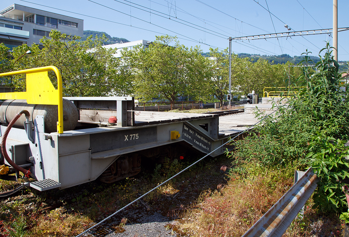 Nochmal im Detail der vierachsige Drehgestell-Tiefbett-Flachwagen als Dienstgüterwagen MOB X 775 der Montreux-Berner Oberland-Bahn, ex RhB Sbk-v 7705, abgestellt am 26.05.2023 in Vevey.

Der Wagen wurde 1999 von der Josef Meyer Waggon AG in Rheinfelden (CH) unter der Fabriknummer 2314 gebaut und an die RhB (Rhätische Bahn AG - Bündner Güterbahn) als Niederflur-Containerwagen Sbk-v 7705 (RhB Serie Sbk-v 7701-7715) geliefert. Im Februar 2013 wurde der Wagen bei der RhB ausrangiert und an die MOB verkauft. Bei der MOB wurde der Wagen umgebaut und an die MOB Normalien angepasst. Zum Umbau gehörte die komplette Belegung des Stahlrahmens mit Holzbohlen, so wurde aus dem Containerwagen ein Tiefbettflachwagen, das Eigengewicht stieg von 14,2 t auf nun 15,6 t. Im Juni 2013 erfolgte die Inbetriebnahme als X 775 bei der MOB.
