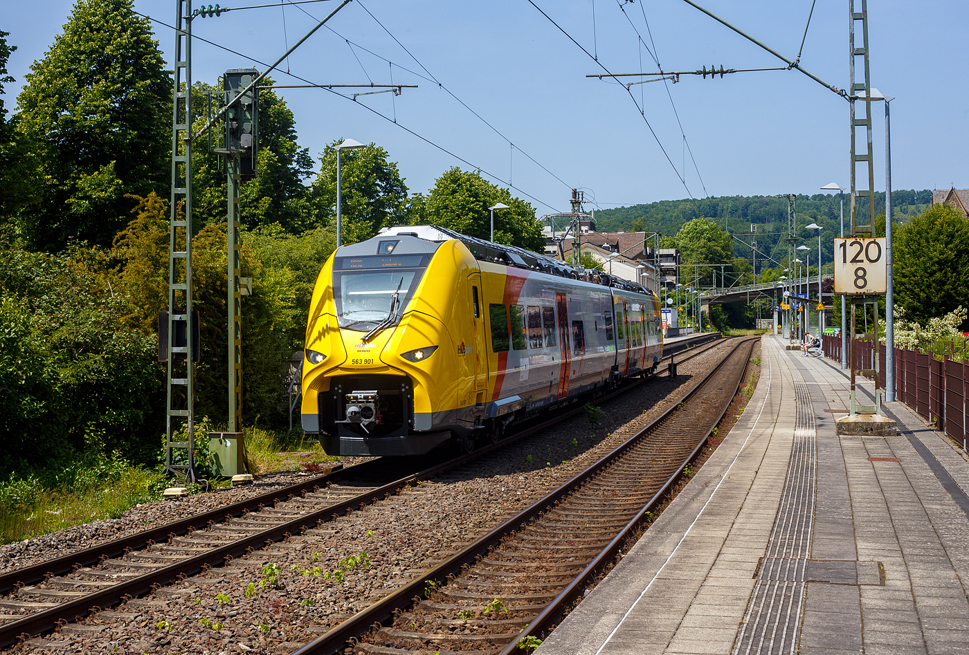 Normalerweise heißt es Dieselnetz Eifel-Westerwald-Sieg (Los 2), zudem auch die Linie RB 90  Westerwald-Sieg-Bahn  von Siegen über Betzdorf/Sieg, Au/Sieg, Altenkirchen/Westerwald und Westerburg nach Limburg/Lahn gehört. Bisher wurde die Verbindung nur mit Dieseltriebzügen der HLB vom Typ LINT 27 oder 41 gefahren. Aber die ca. 40 km lange Strecke zwischen Siegen und Au/Sieg ist elektrifiziert. Den weiteren ca. 78 km sind aber ohne Oberleitung. 

Nun wird aber auch hier elektrisch gefahren und zwar mit Hybridtriebzügen (E/Akku) vom Typ SIEMENS Mireo Plus B. Ein großer Fortschritt für den Klimaschutz am Westerwald.

Hier verlässt der HLB 563 801 / 563 901 (94 80 0563 801-0 D-HEB / 94 80 0563 901-8 D-HEB), ein zweiteiliger Hybridtriebzug (E/Akku) der BR 563 vom Typ SIEMENS Mireo Plus B der HLB (Hessische Landesbahn GmbH), am Freitag den 13 Juni 2025 den Bahnhof Kirchen/Sieg und fährt weiter in Richtung Betzdorf.