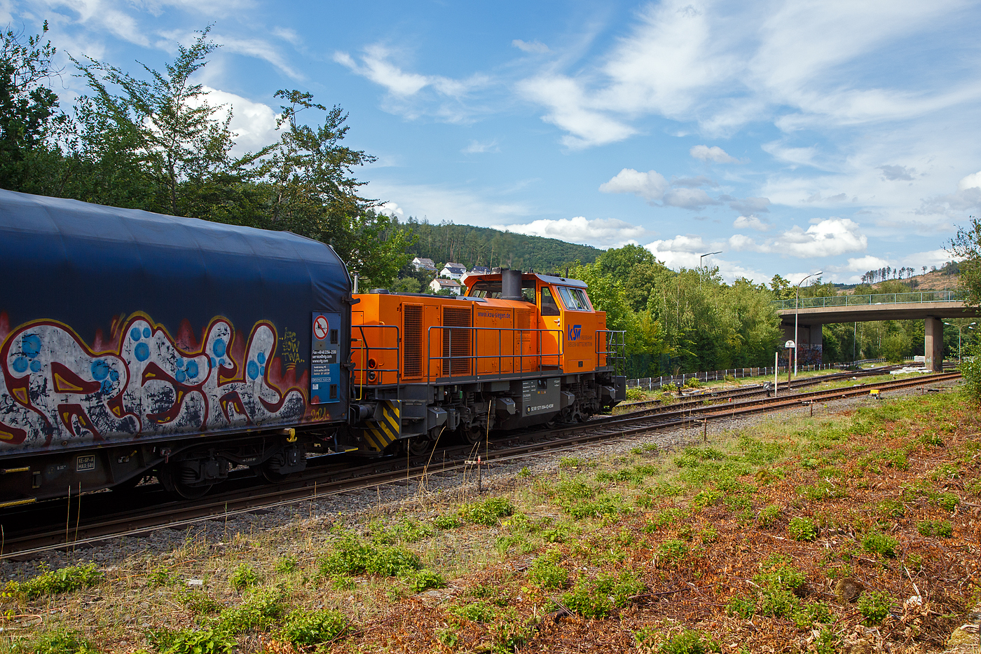 Nun fährt am 12.07.2023 die KSW 44 (92 80 1271 004-4 D-KSW) eine MaK G 1000 BB der KSW (Kreisbahn Siegen-Wittgenstein) mit einem Coilzug vom Bahnhof Herdorf weiter. Von hier geht es gleich auf den KSW Rbf (Betriebsstätte Freien Grunder Eisenbahn - NE 447) und ohne Halt direkt weiter nach Neunkirchen-Salchendorf zum Pfannenberg (ehemals Grube Pfannenberger Einigkeit), wo sich heute die Produktionshallen der EMW Stahl Service GmbH, ein Geschäftsbereich der SCHÄFER WERKE Gruppe befinden. Schon heute werden 300.000 Tonnen Stahl pro Jahr über die Schiene angeliefert, zukünftig sind sogar 600.000 Tonnen geplant.