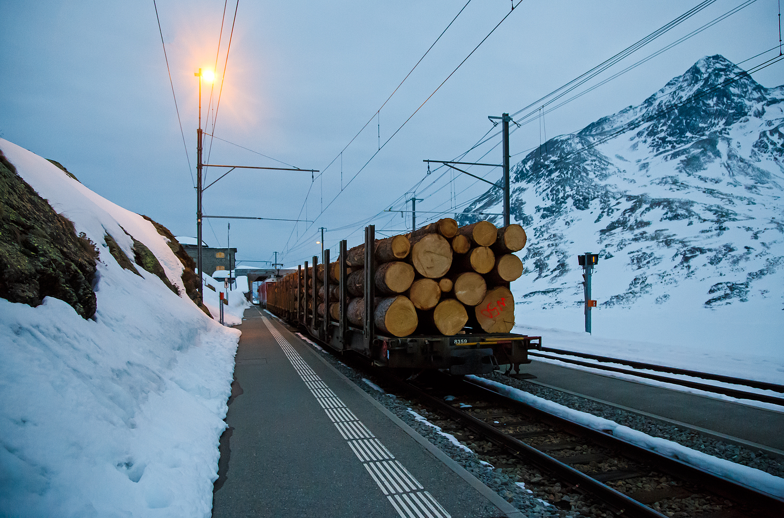 Nun haben die beiden RhB ABe 4/4 III Triebwagen 54  Hakone  und  51  Poschiavo  am 21.03.2023 als PmG (Personenzug mit Gterbefrderung) nach Poschiavo, fahren nun vom hchsten Punkt der Berninabahn, den Bahnhof Ospizio Bernina weiter nach Poschiavo.

Ab hier sind nun eher die Bremsen gefordert, denn nun geht es bis nach Poschiavo fast nur bergab. Von Pontresina nach Ospizio Bernina geht es nur bergauf, und wir merkten wie die Triebwagen arbeiten mussten.