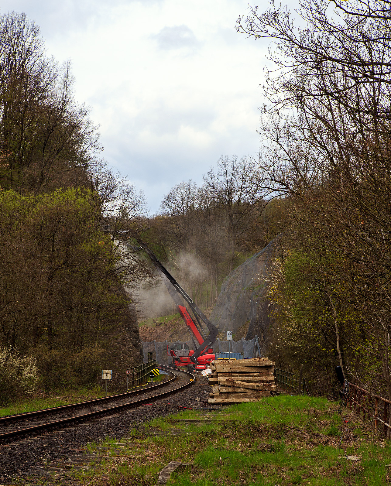 Nun haben die Felssicherungsarbeiten endlich begonnen....
Am 23. Dezember 2022 ca. 18:15 Uhr kam es hier, in Herdorf kurz hinter dem Hp  Knigsstollen (bei km 88,4 der Hellertalbahn KBS 462), zu einem Felssturz und der HLB Triebwagen VT 507, als RB 96 „Hellertalbahn“ entgleiste, verletzt wurde zum Glck niemand. Nun nach ber vier Monaten haben endlich die erforderlichen Sicherungsmanahmen begonnen. Zuerst mssen viele 4 m lange Anker in den Fels getrieben werden. Die Arbeiten werden von der Firma FELDHAUS Bergbau GmbH & Co. KG aus Schmallenberg (Hochsauerland) ausgefhrt. Hier am 26.04.2023.