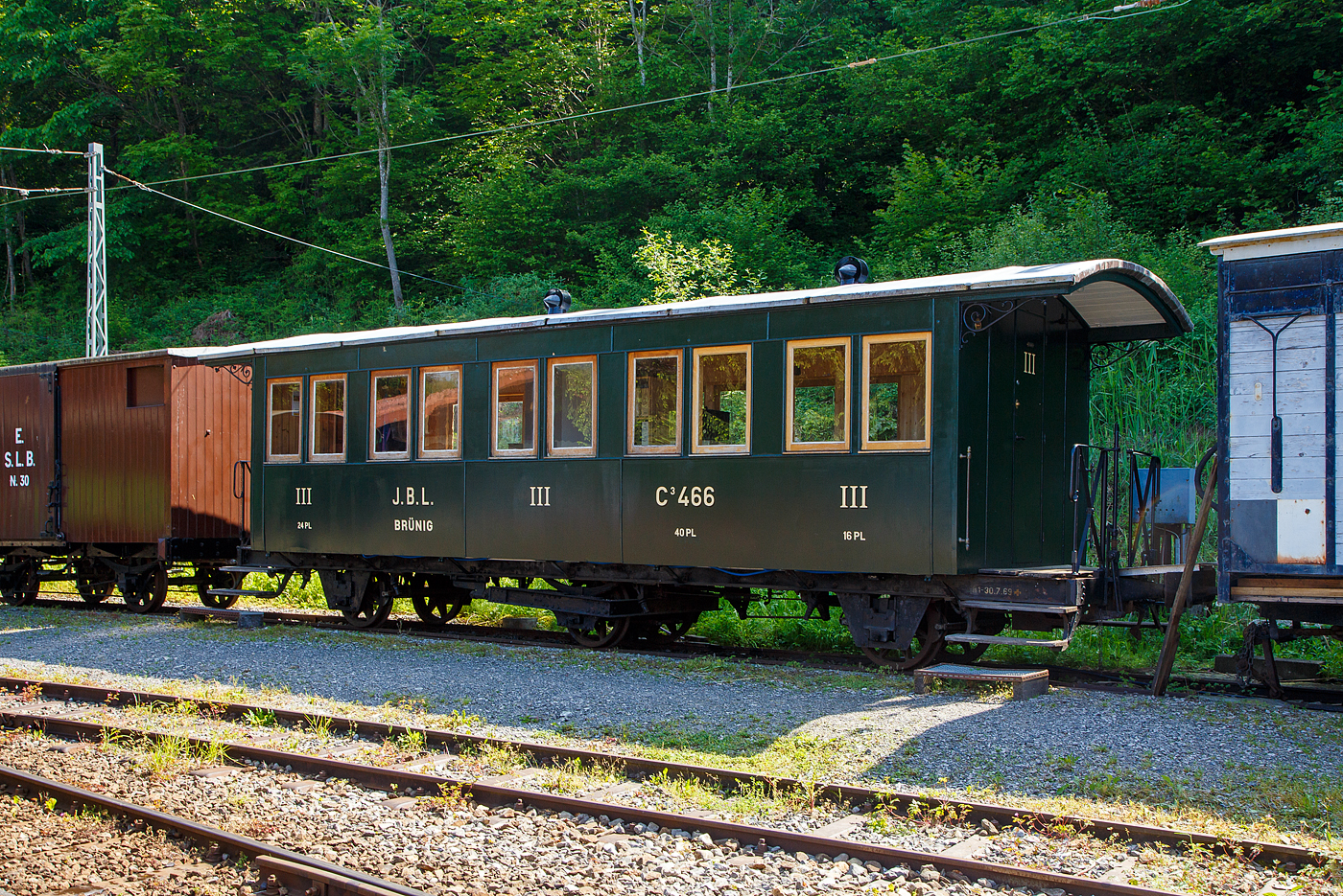 Personenwagen mit offenen Plattformen (Plattformwagen) J.B.L. BRÜNIG C³ 466 der Museumsbahn Blonay–Chamby (BC) abgestellt am 27.05.2023 auf dem Museums-Areal der (BC) in Chaulin. Bei der BC wird er derzeit als Essraum der Vereinsmitglieder verwendet.   

Der Wagen wurde 1889 von der Schweizerische Industrie Gesellschaft (SIG) in Neuhausen am Rheinfall (damals noch als Schweizerische Waggonfabrik geführt) gebaut und an die JBL Brünig (Jura–Bern–Luzern) geliefert. Am 1. Januar 1890 fusionierte die Jura–Bern–Luzern mit den Suisse-Occidentale–Simplon (SOS) zur Jura-Simplon-Bahn (JS). Mit der Verstaatlichung der JS zu den Schweizerischen Bundesbahnen (SBB-Brünigbahn) am 1. Mai 1903 wurde der ganzjährige Betrieb eingeführt. Die Bahn war bis zum 31. Dezember 2004 die einzige Schmalspurstrecke und die einzige Zahnradbahn im Netz der SBB. Am 30. Juni 2004 hat der Bundesrat die SBB ermächtigt, die meterspurige Brünigbahn an die Luzern-Stans-Engelberg-Bahn (LSE) zu verkaufen. Die Konzession der LSE wurde auf die Brünigbahn ausgedehnt. Seit dem 1. Januar 2005 verkehrt die fusionierte Bahngesellschaft unter dem neuen Namen Zentralbahn (zb).

Bei der SBB-Brünigbahn der Wagen als SBB C³ 633, mit der Aufhebung der dritten Wagenklasse wurde er zum SBB B³ 633, zuletzt war er als Dienstwagen X³  9951im Einsatz und im März 1974 ging er an die BC.

TECHNISCHE DATEN:
Typ: C³
Baujahr: 1889
Hersteller: SIG
Spurweite: 1.000 mm (Meterspur)
Achsanzahl: 3 (Achsfolge 2'2')
Länge über Puffer: 9.780 mm
Kastenlänge: 7.690 mm (ohne Plattformen)
Plattformlänge: jeweils 635 mm
Achsabstände: 2 x 3.000 = 6.000 mm
Eigengewicht: 8,0 t
Sitzplätze: 40 in der 3. Klasse