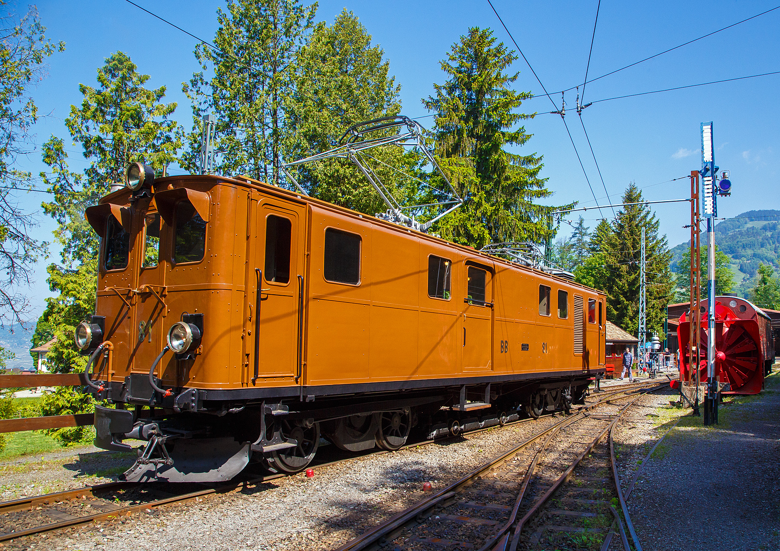 Pfingsten 2023 (Samstag 27. bis Montag 29. Mai 2023) fand bei der Museumsbahn Blonay–Chamby das Schweizer Dampffestival 2023 / Festival suisse de la Vapeur 2023 statt.

Die grandiose ehemalige Berninabahn RhB Ge 4/4 81 der Museumsbahn Blonay–Chamby, ex RhB Ge 4/4 181, ex BB Ge 4/4 81, ex BB Ge 6/6 81, am 27. Mai 2023 beim Umsetzen auf dem Museums-Areal der (BC) in Chaulin. Eigentlich da die Lokomotive ein kleines Gepckabteil und sechs Achsen besitzt, msste sie als Triebwagen De 4/6 bzw. Fe 4/6 (ex Fe 6/8) klassifiziert sein, aber die Berninabahn und spter die RhB wollten sie als Lokomotive und nicht als Triebwagen klassifizieren.

Rechts ein weiteres Relikt der Berninabahn, die Selbstfahrende Dampfschneeschleuder R 1052 (ex BB R 1052 (Berninabahn), ex RhB R 14, ex RhB Xrot d 9214), der Museumsbahn Blonay-Chamby. Dieses Fahrzeug wie auch das heute noch bei der RhB betriebsfhige Schwesterfahrzeug Xrot d 9213 (ex BB R 1051) sind dampfgetriebene Schneeschleudern mit eigenem Antrieb die fr die Berninabahn (BB) gebaut wurden, die seit 1944 zur Rhtischen Bahn gehrt. Im Gegensatz zu den bisher gebauten Fahrzeugen, auch der zwei Dampfschleudern der RhB-Stammstrecke, handelt es sich bei den beiden Bernina-Schleudern um selbstfahrende Fahrzeuge. Die Berninabahn entschied sich hierzu, weil in den engen Kurven mit nicht gengend hoher Kraft geschoben werden konnte und die Bahn selbst keine Fahrdraht-unabhngigen Triebfahrzeuge besa. Die Schleudern wurden dennoch normalerweise mit Schiebetriebfahrzeugen eingesetzt, damit die gesamte Kesselleistung fr die Dampfmaschine des Schleuderrades zur Verfgung stand.

Die Ge 4/4 81war ursprnglich eine sechsachsige Elektrolokomotive (Ge 6/6) der ehemaligen Berninabahn (BB), welche 1943 in der Rhtischen Bahn (RhB) aufging. Als Einzelstck wurde sie von der Schweizerischen Lokomotivfabrik in Winterthur (SLM) mit elektrischer Ausrstung von Brown, Boveri & Cie. (BBC) hergestellt und 1916 abgeliefert. Als schmalspurige Elektrolokomotive mit sechs angetriebenen Achsen erhielt sie die Bauartbezeichnung Ge 6/6 und die Betriebsnummer 81, bereits 1929 wurde sie bei der SLM in Winterthur zur BB Ge 4/4 81 umgebaut.

Die damals rasche Verkehrszunahme verlangte nach einer eigenen Lokomotive fr den schweren Verkehr. Mit einem Gewicht von 45 Tonnen, verteilt auf ursprnglich sechs Antriebsachsen und zwei kleine Achsen fr den Hilfsrahmen des Bremsgestells mit der elektromagnetischen Schienenbremse, und vier Fahrmotoren galt sie damals als strkste meterspurige Lokomotive Europas. Je zwei Motoren waren in einem Drehgestellrahmen fest verschraubt, die Kraftbertragung erfolgte von der Motorwelle zunchst auf eine Vorgelegewelle. Die beiden Vorgelegewellen und die mittlere Triebachse jedes Drehgestells waren mit einem Dreiecksrahmen verbunden. Die ueren Achsen wurden mittels Kuppelstangen angetrieben. Diese Anordnung bewhrte sich nicht. Es ist berliefert, dass eine Dreieckskuppelstange in voller Fahrt nach Bruch der Kurbeln durch das Dach geschleudert wurde.

Umbau zur Ge 4/4 81:
1929 wurde die Lok von der Achsfolge C’C’ auf die Achsfolge B’B’, beim Hersteller SLM in Winterthur, umgebaut. Durch den Umbau sollte die Leistung der Lok fr geplante Express-Zge erhht werden. Die mittlere Achse jedes Drehgestells wurde durch eine Blindwelle ersetzt. Die Kraftbertragung von den Motoren her erfolgt neu durch ein Getriebe. Die Triebachsen werden durch Schlitzkuppelstangen angetrieben. Beim Umbau wurde die Lok auf die bevorstehende Spannungserhhung von 750 Volt auf 1000 Volt vorbereitet. Dadurch konnte die Leistung von 960 PS auf 1040 PS gesteigert werden. Die zulssige Hchstgeschwindigkeit wurde von 50 km/h auf 45 km/h gesenkt.

Als Besonderheit besitzt die Lokomotive einen mit zwei Achsen ausgersteten Hilfsrahmen fr die aus der Fahrleitung gespeiste elektromagnetische Schienenbremse. Infolge dieses Hilfsrahmens htte die Lokomotive korrekterweise die Achsfolge B’2’B’, ursprnglich C’2’C’. Die Bauartbezeichnung einschlielich des Bremsgestells wrde Ge 4/6 (beziehungsweise frher Ge 6/8) lauten, unter Bercksichtigung des Gepckabteils De 4/6 (frher Fe 4/6 beziehungsweise Fe 6/8).

Bei der Rh B - Rhtischen Bahn erhielt die Lokomotive 1961 die Betriebsnummer 181. 1970 wurde sie ausgemustert und kam zur Museumsbahn Blonay–Chamby (BC), wo sie anfnglich regelmig eingesetzt wurde. Ab 1990 verhinderte ein Schaden an der elektrischen Ausrstung die weitere Nutzung. Erst 2008 konnte die Lokomotive mit Hilfe eines Sponsors so weit aufgearbeitet werden, dass sie seither wieder eingesetzt werden kann.

Am 23. August 2021 wurde die Lok auf der Strae nach Landquart berfhrt, damit sie Anfang Oktober bei Sonderfahrten auf der Berninabahn eingesetzt werden konnte. Nachdem die BC und der Club 1889, der in Samedan historische Fahrzeuge der RhB erhlt, die Lokomotive fr den Einsatz am Bernina angepasst haben, zog die Lokomotive im Februar 2022 aus eigener Kraft einen Extrazug von St. Moritz zur Station Alp Grm (2.091 m..M.). In Folge wurde die Maschine fr weitere Sonderfahrten auf ihrer ehemaligen Stammstrecke eingesetzt und kehrte erst im Oktober 2022 wieder zur Museumsbahn BC zurck.

TECHNISCHE DATEN  der Ge 4/4 81 (Ge 4/6):
Betriebsnummern: BB 81 / RhB 81 / RhB 181
Gebaute Anzahl: 1 (Eizelstck)
Hersteller mecha. Teil: Schweizerischen Lokomotivfabrik in Winterthur (SLM) 
Elektrischer Ausrstung:  Brown, Boveri & Cie., Mnchenstein (BBC)
Inbetriebsetzung: 1916  (1929 Umbau von der Ge 6/6 zur Ge 4/4)
Spurweite: 1.000 mm (Meterspur)
Achsanordnung: B’B’, ursprnglich C’C’
Lnge ber Puffer: 13.900 mm
Hhe ber S.o.K.: 3.840 mm (abgesenkter Stromabnehmer) / 6.250 mm gehoben 
Drehzapfenabstand: 7.560 mm
Achsabstand im Drehgestell: 2.100 mm (Achse/Motor/Achse 1.150 / 950 mm)
Treibraddurchmesser: 855 mm (neu)
Achsabstand im Bremswagen: 1.360 mm
Laufraddurchmesser im Bremsgestell: 280 mm (neu)
Dienstgewicht: 46,0 t
Hchstgeschwindigkeit: 45km/h (anfnglich 50 km/h)
Dauerleistung: 708 kW (4 x 177 kW) / 962 PS (urspr. 455 kW / 620 PS) 
Anfahrzugkraft: 14.500 kg
Getriebebersetzung: 1:4.28
Stromsystem: 900 V  DC (Gleichstrom)
Strombertragung: 2 Stromabnehmer
Anzahl der Fahrmotoren: 4
Antrieb: elektrisch
Bremse: Vakuumbremse, elektrische Widerstandsbremse, Magnetschienenbremsen